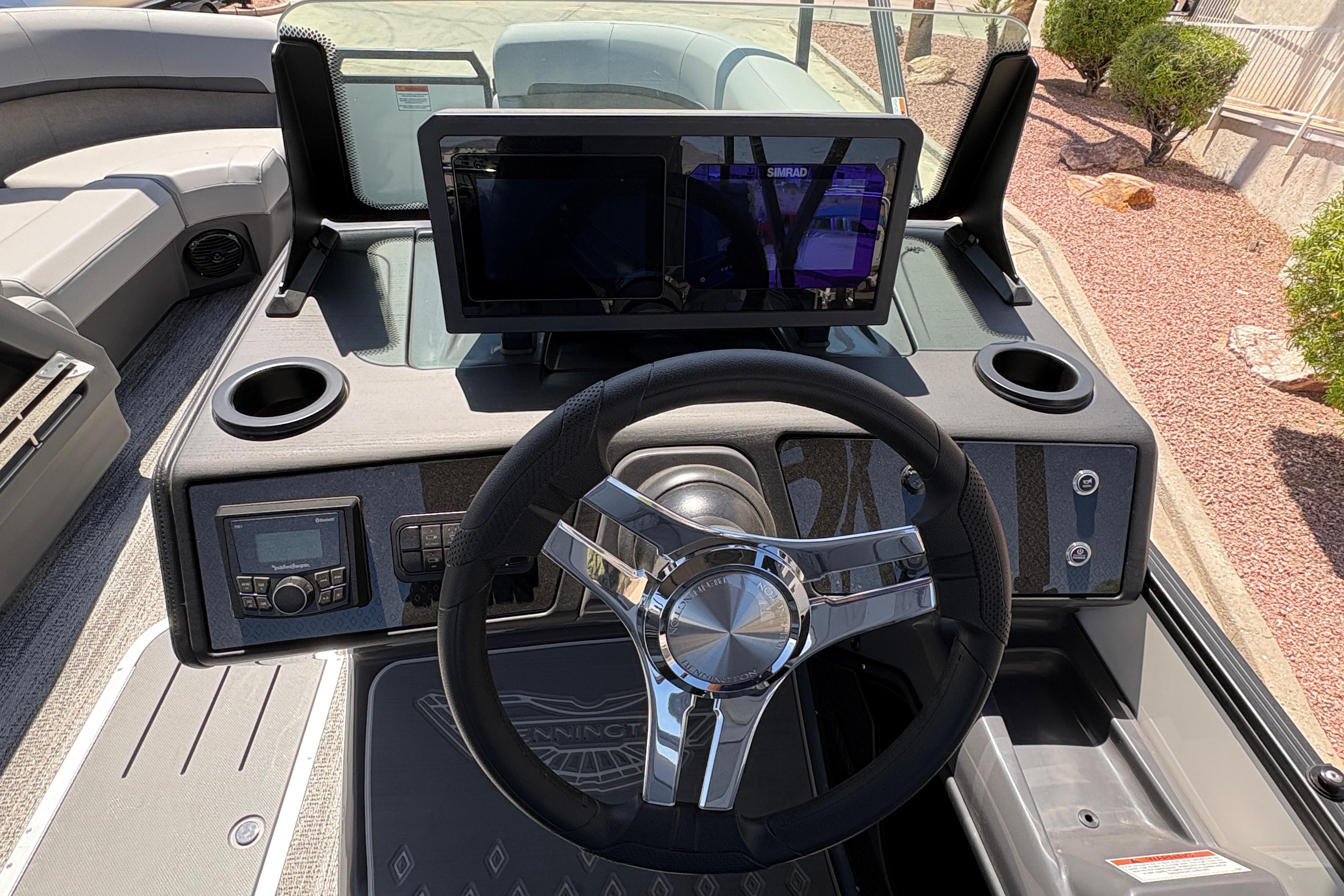 2026 Bennington 22 MSB boat dashboard with steering wheel and digital display.