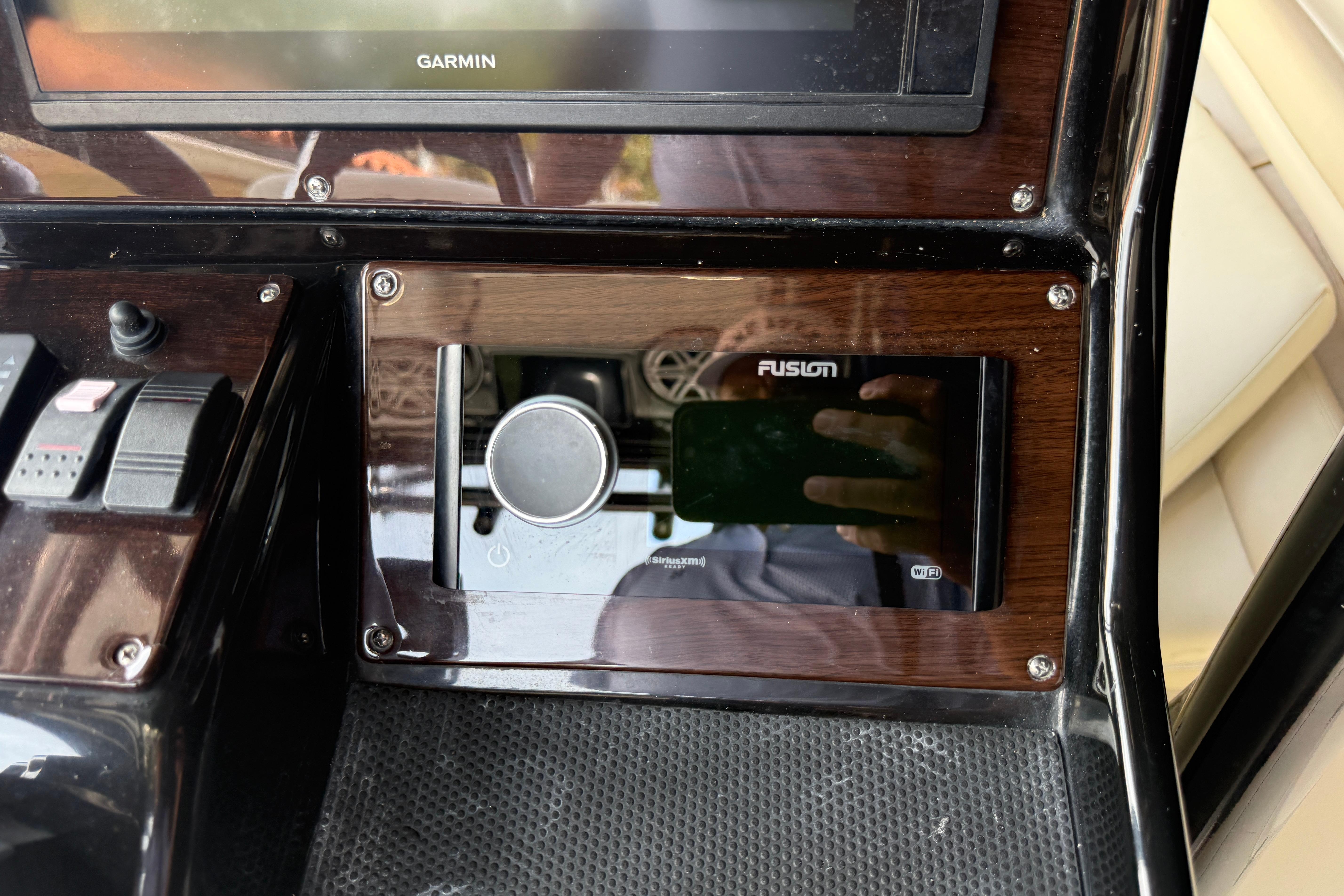 Control panel of a 2015 Blackwood 27 boat featuring Garmin and Fusion systems.
