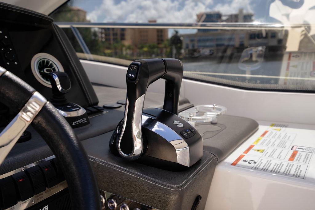 Control panel of 2022 Schaefer 400 Sport yacht with throttle levers and steering wheel.