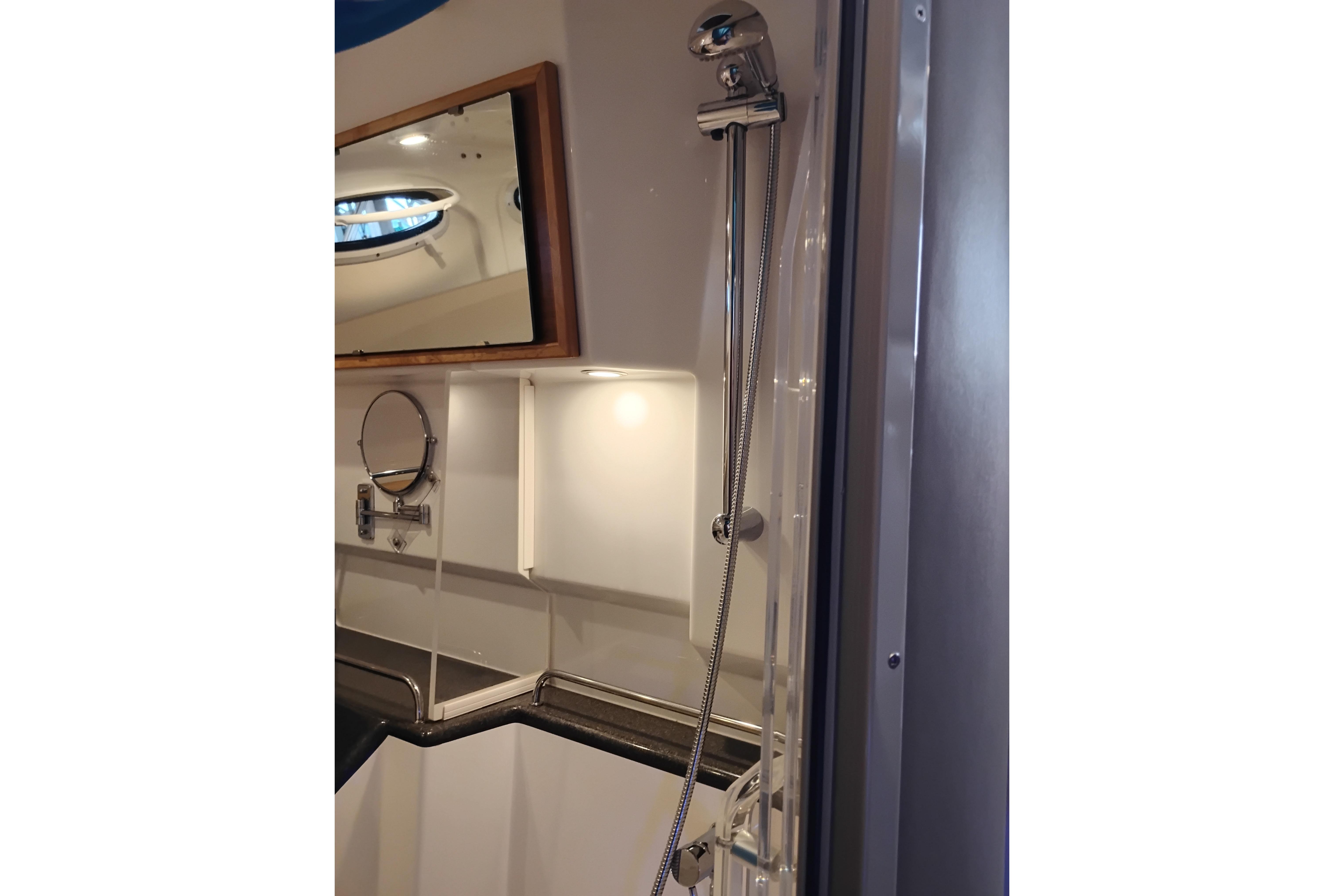2022 Cutwater C-32 Coupe bathroom with shower, mirror, and modern fixtures.