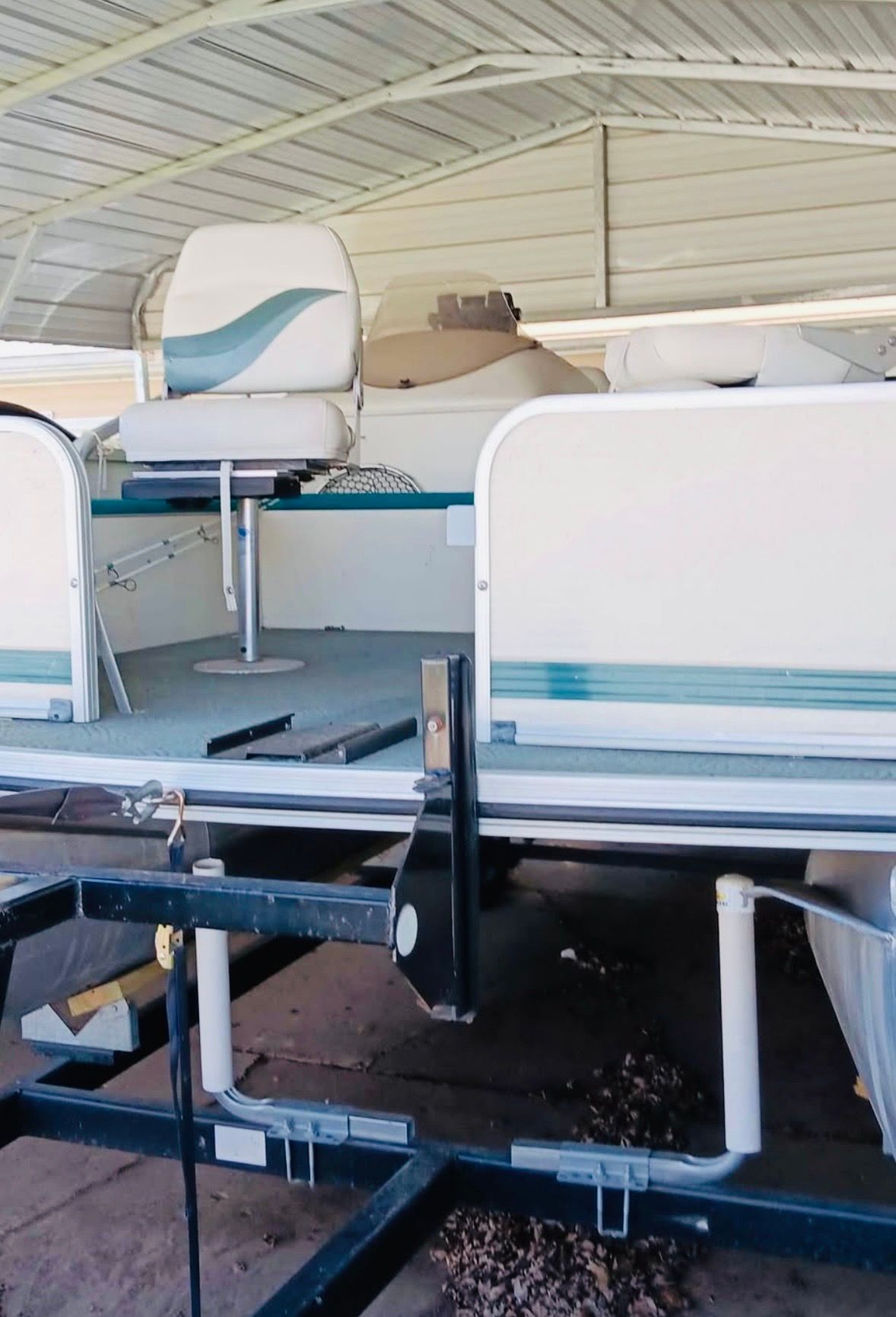A 2001 Lowe Trinidad 204 pontoon boat on a trailer in a covered area.