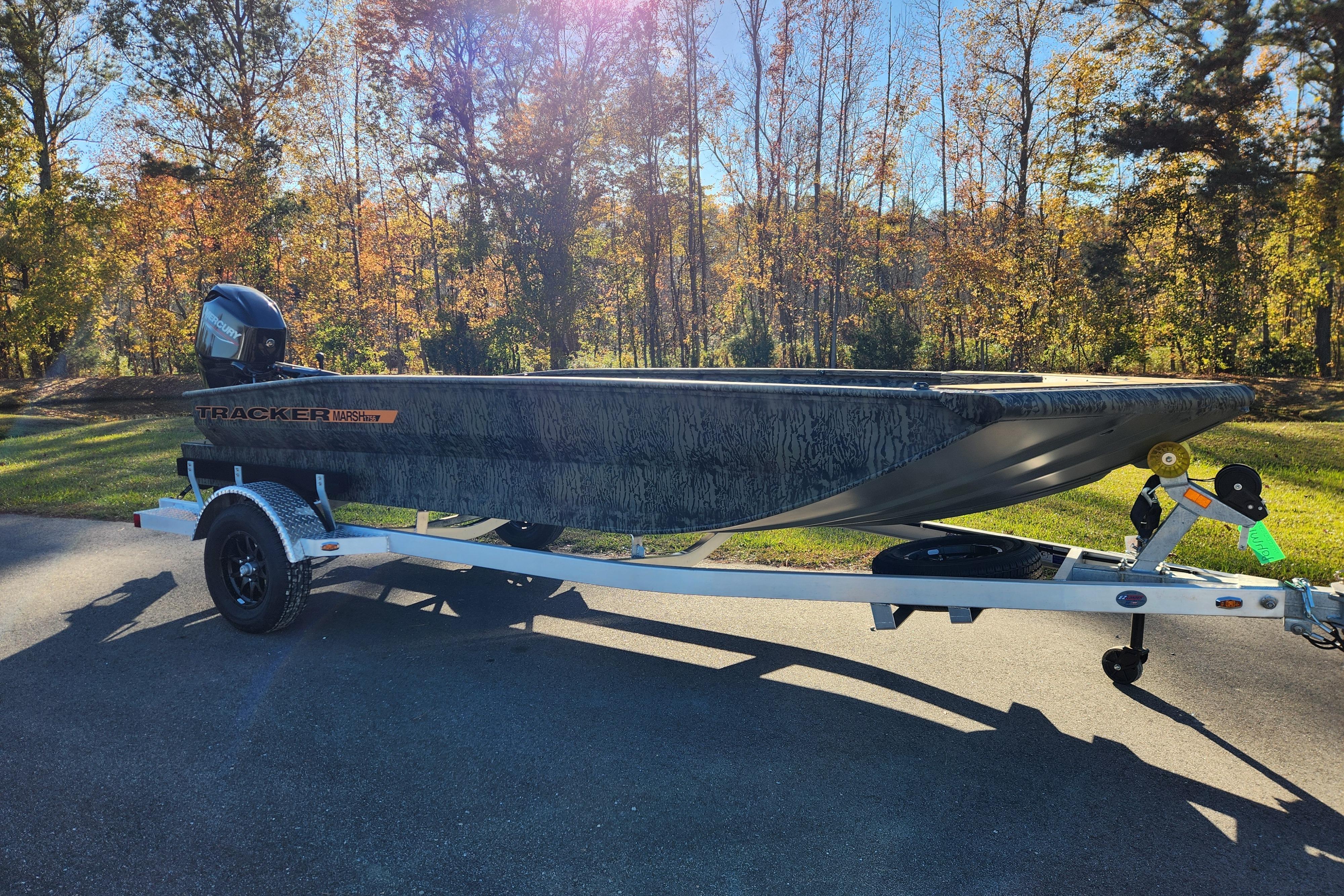 2026 Tracker Grizzly 1756 T Marsh boat on trailer, surrounded by autumn trees.