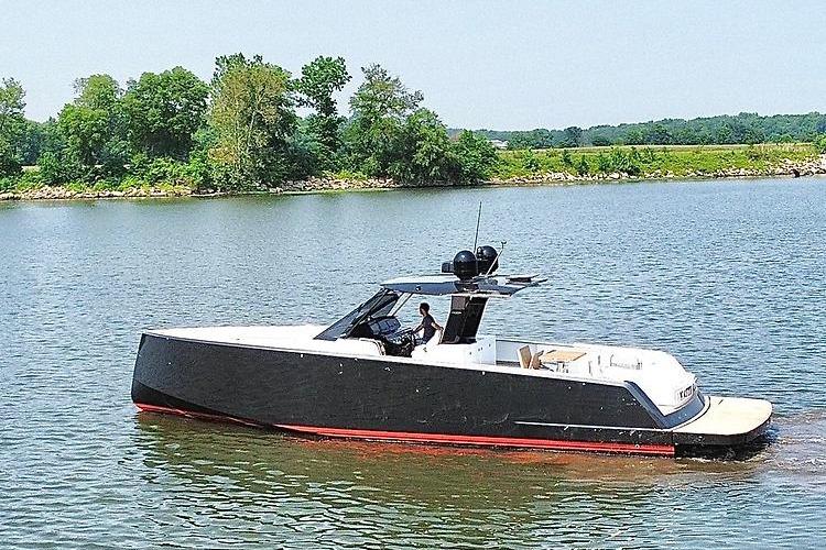2023 Pardo Yachts P43 cruising on a serene lake with lush green shoreline.