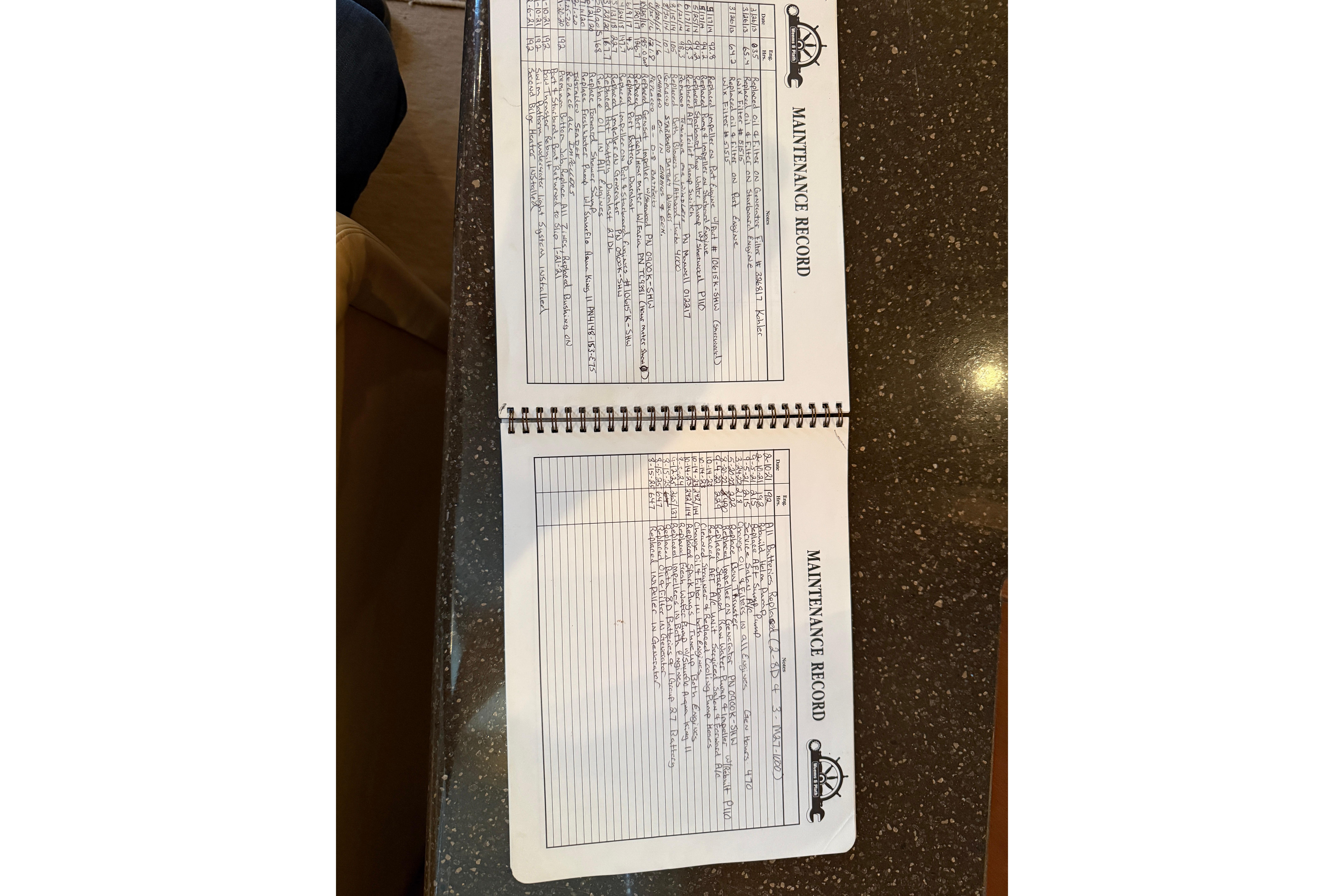 Open maintenance record book for 2005 Silverton 43 Motor Yacht on a table.