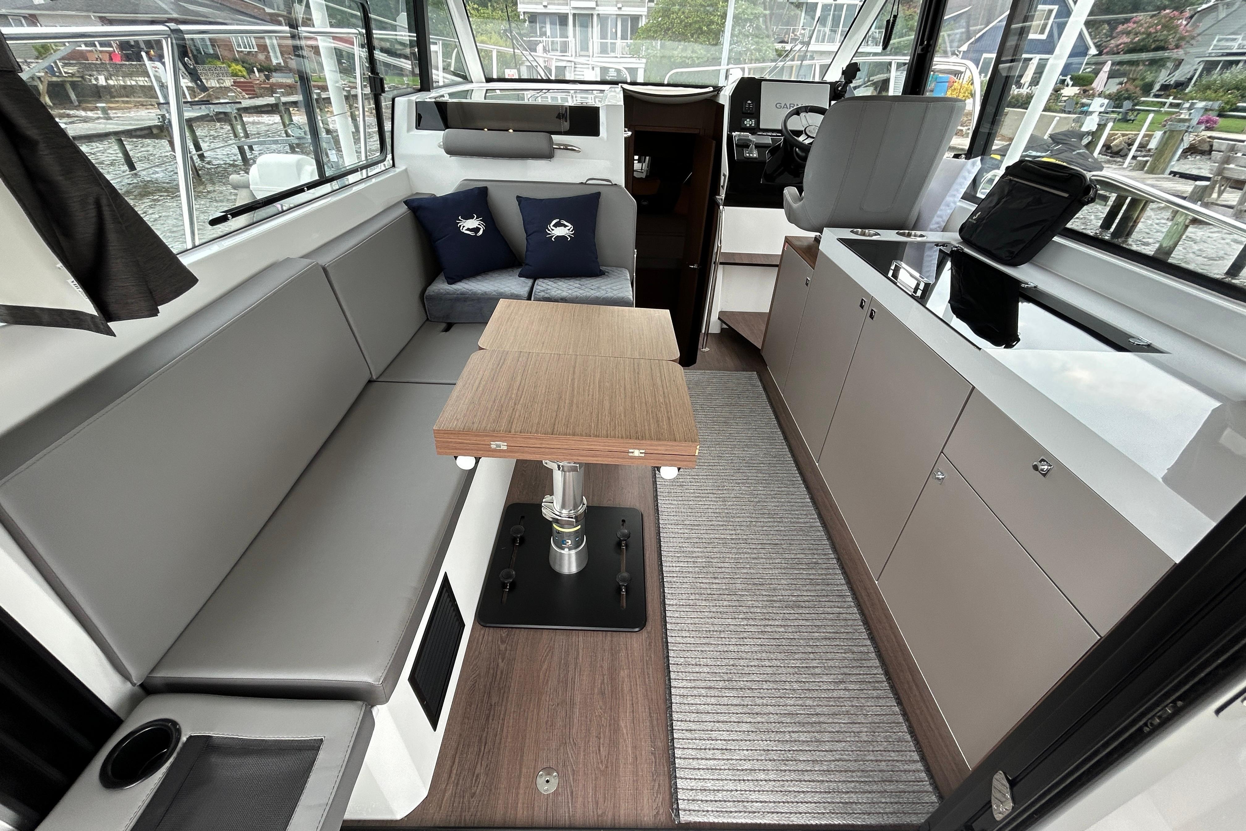 Interior of 2024 Beneteau Antares 11, featuring modern seating and sleek cabinetry.