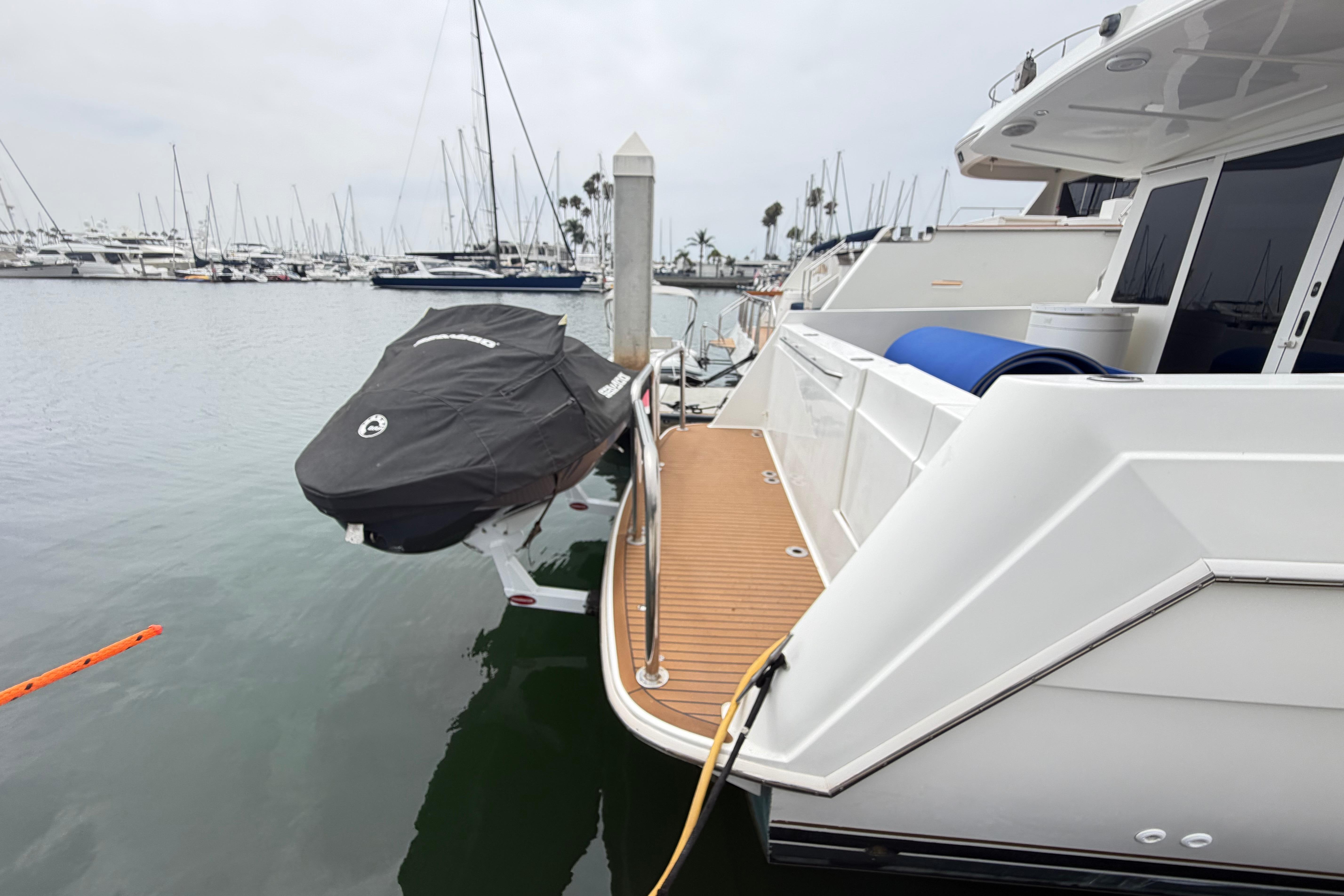 2005 Navigator 53 Pilot House yacht docked with covered jet ski on lift.