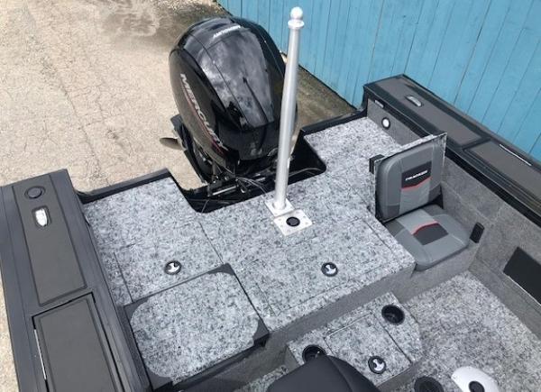 2025 Tracker Targa V18 Combo boat interior with motor and seating, featuring gray carpeting.