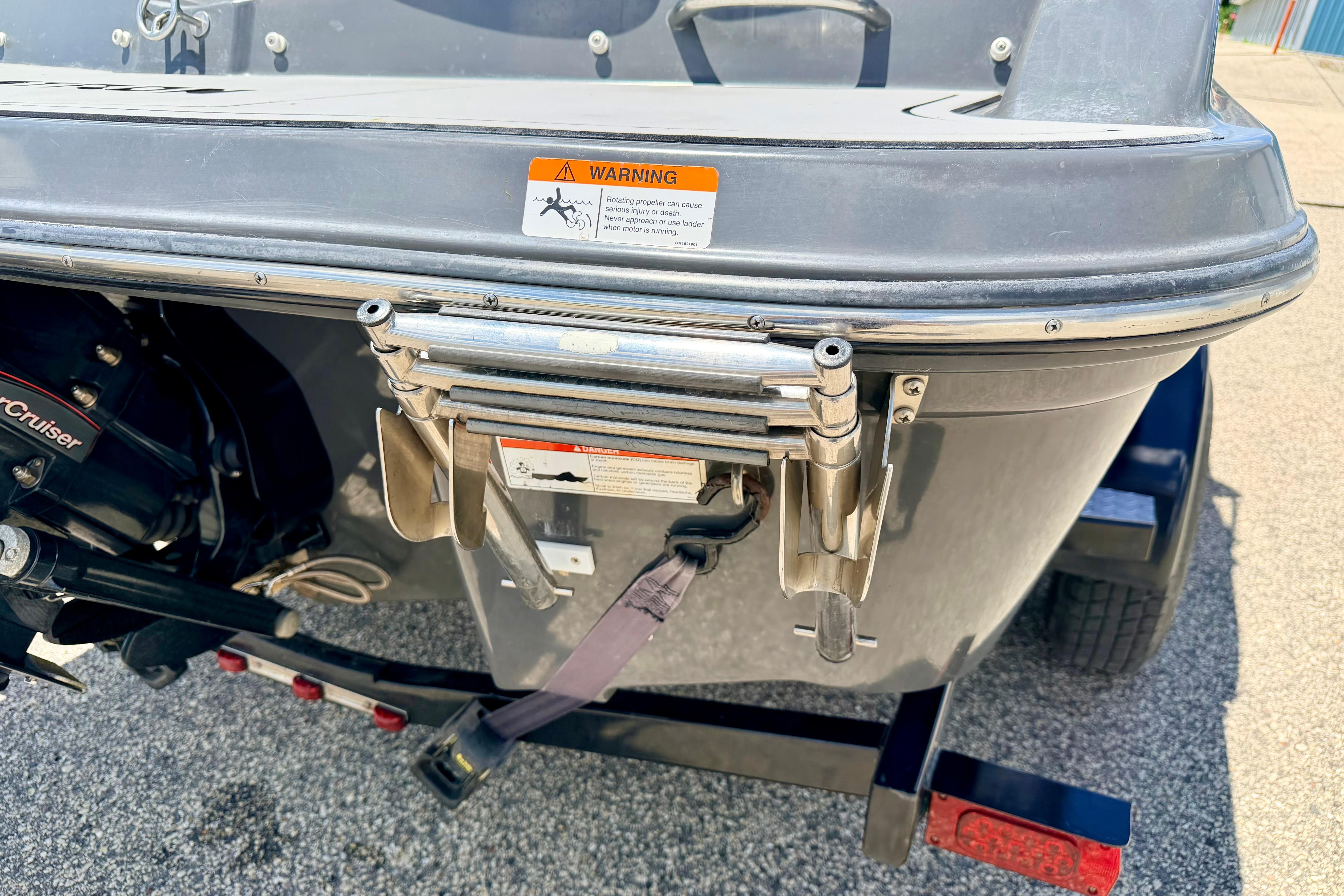 Rear view of a 2018 Glastron GT 185 boat with ladder and warning label.