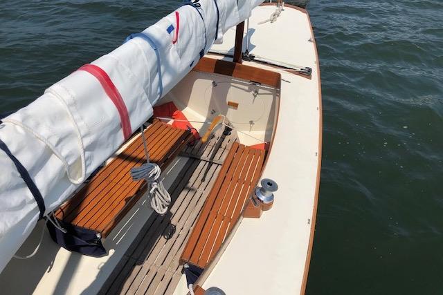 1963 Cape Cod Shipbuilding Shields sailboat with wooden benches on calm water.