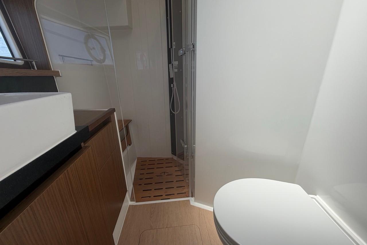 Modern bathroom interior of 2022 Sealine C430 yacht with shower and wooden accents.