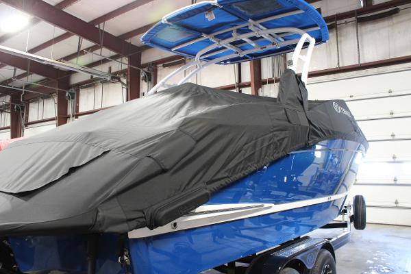 2025 Cobalt R6 boat covered in a garage, featuring a blue hull and black cover.