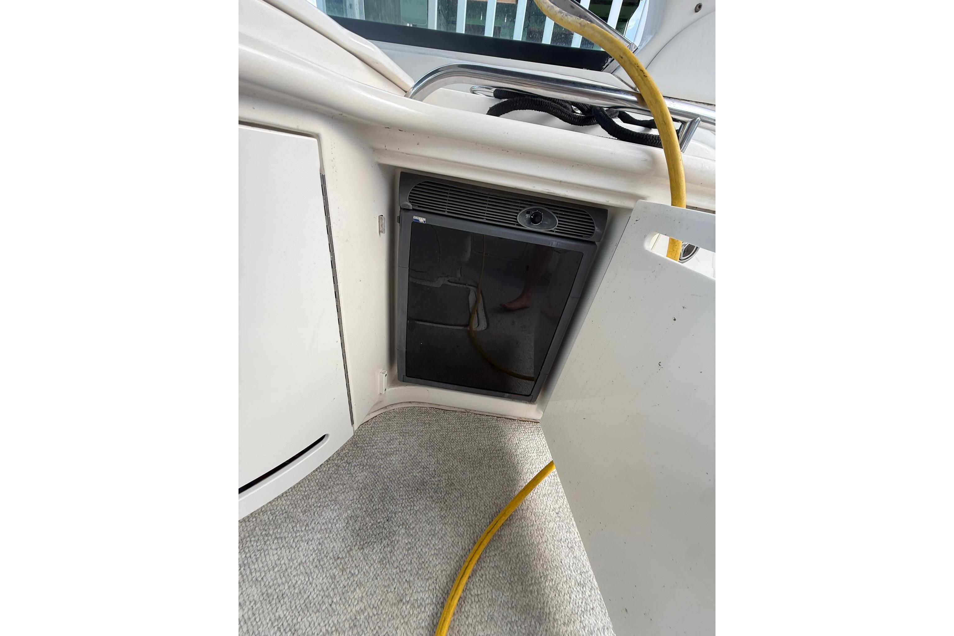 2005 Sea Ray 290 SLX boat interior with mini fridge and storage compartment.