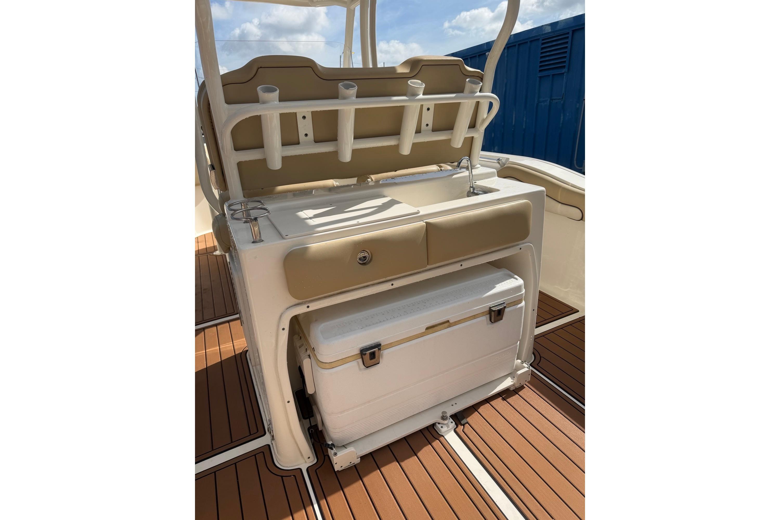 2019 Key West 263 FS boat interior with sink, rod holders, and cooler on deck.