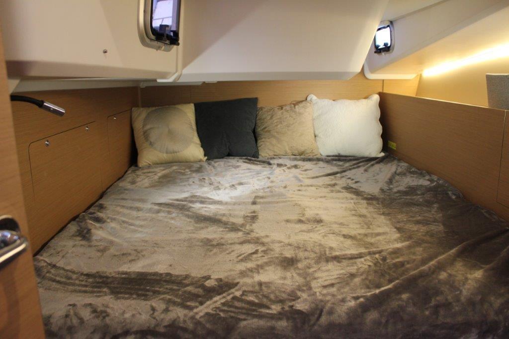 Cozy cabin interior of 2024 Jeanneau Sun Odyssey 490 with plush bedding.