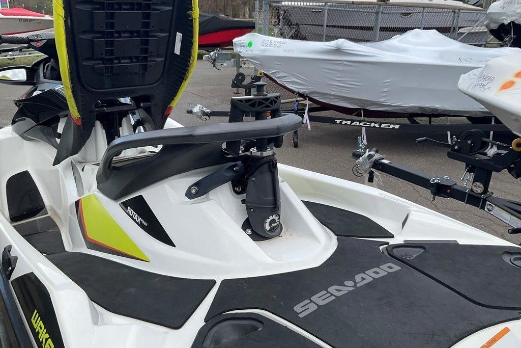 2014 Sea-Doo Wake Pro 215 jet ski with Rotax engine, parked near covered boats.