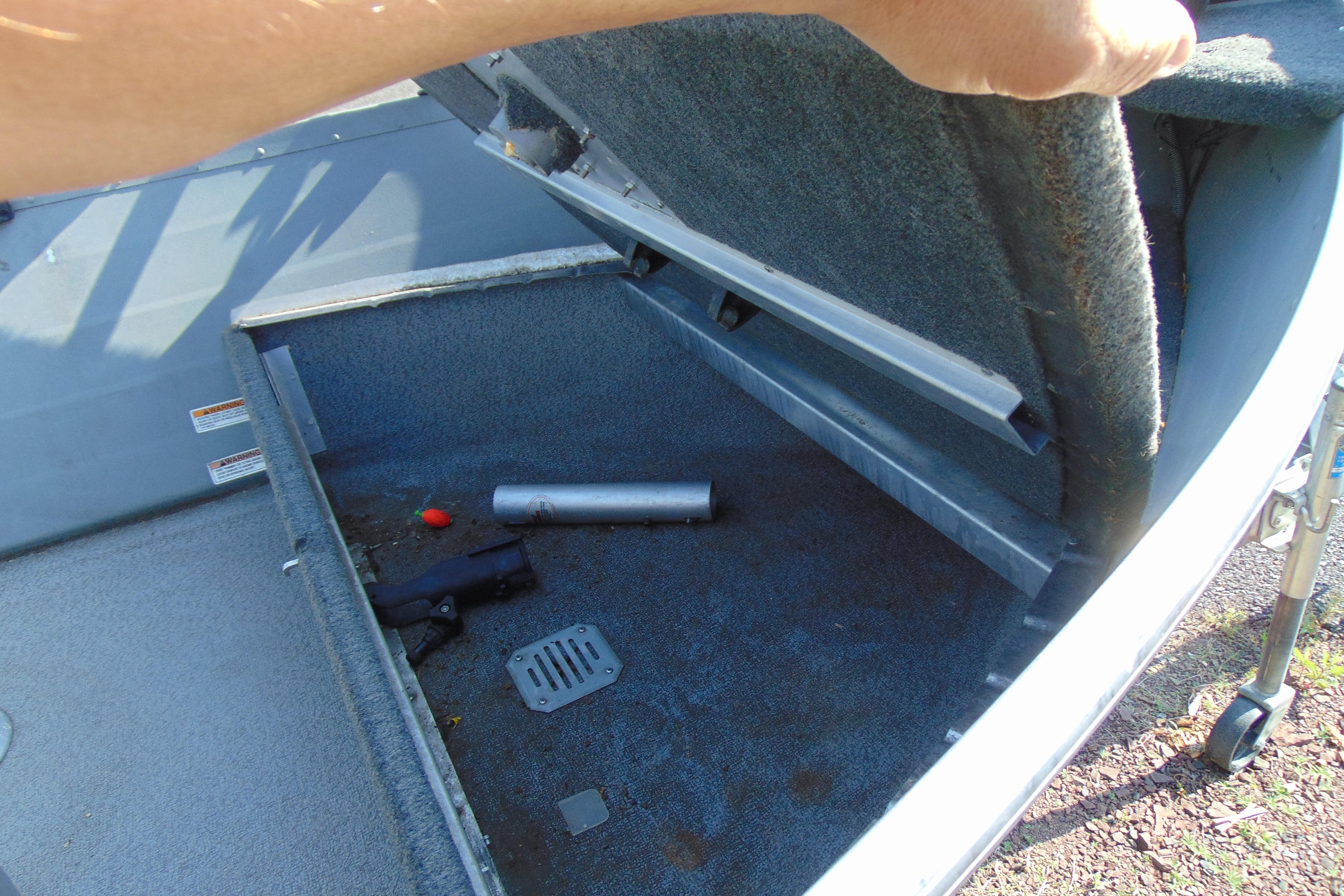 Open storage compartment in 2017 Starcraft SF 16 DLX boat, revealing interior contents.
