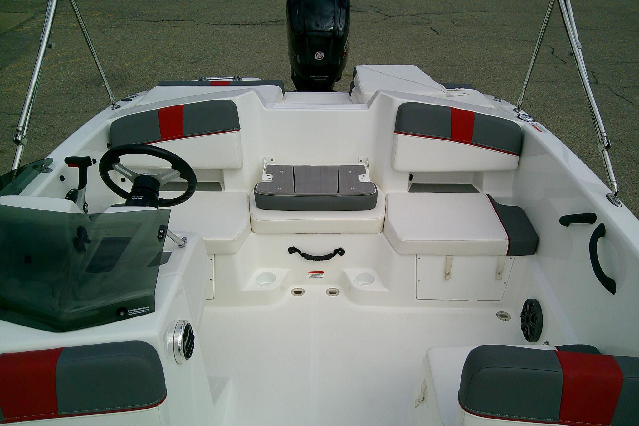 2024 Tahoe T18 boat interior with gray and red seating, steering wheel, and storage compartments.
