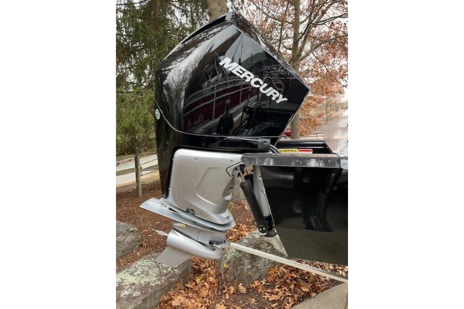 2023 Regency 230 LE3 Sport boat with Mercury outboard motor in a wooded setting.