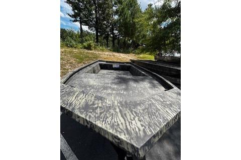 2025 Tracker Grizzly 1860 Utility boat with camouflage design in outdoor setting.