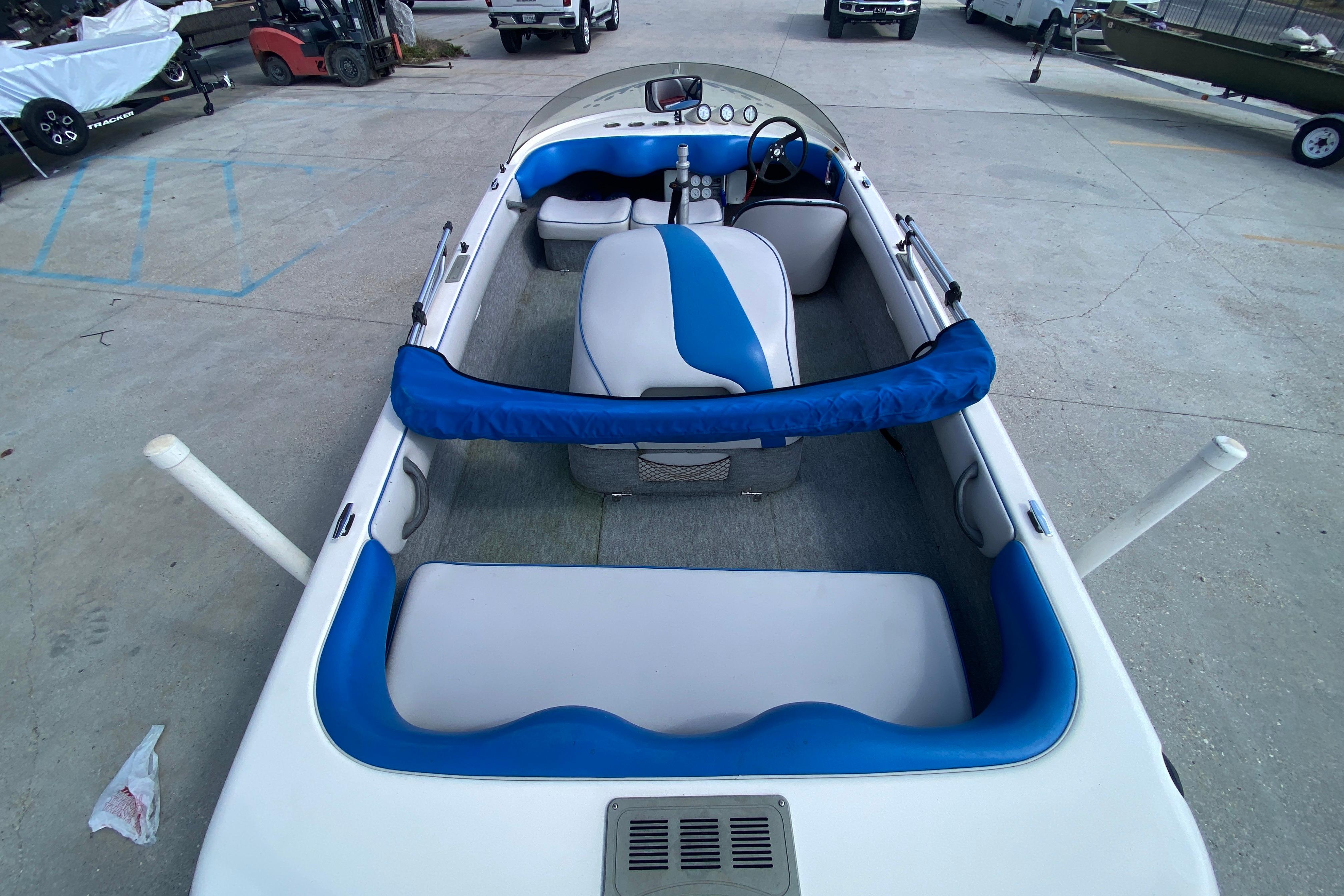 1997 Malibu Tantrum boat interior with blue and white seating, parked on concrete.