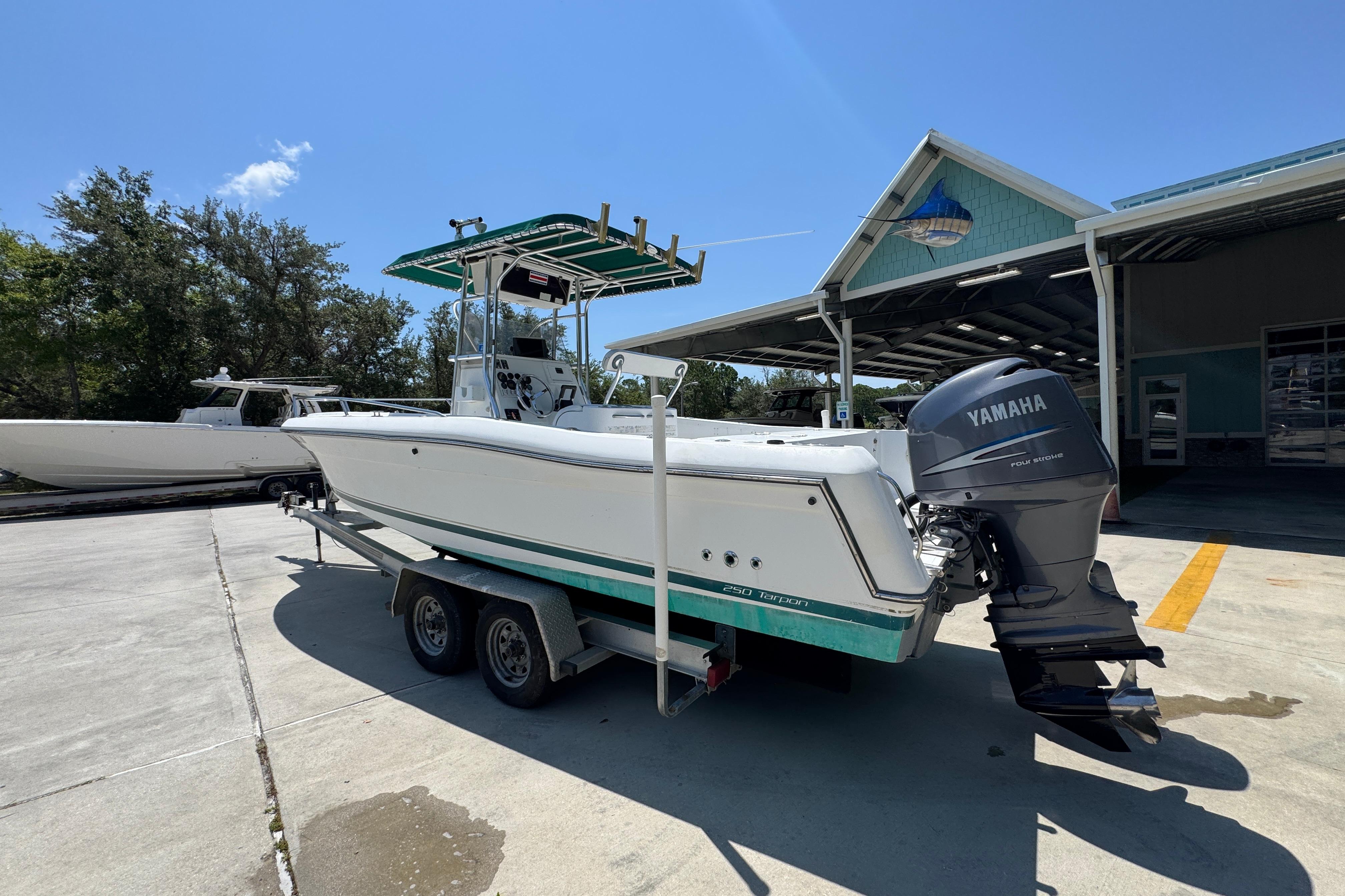 2000 Stamas 250 Tarpon boat with Yamaha engine on trailer, parked outdoors.