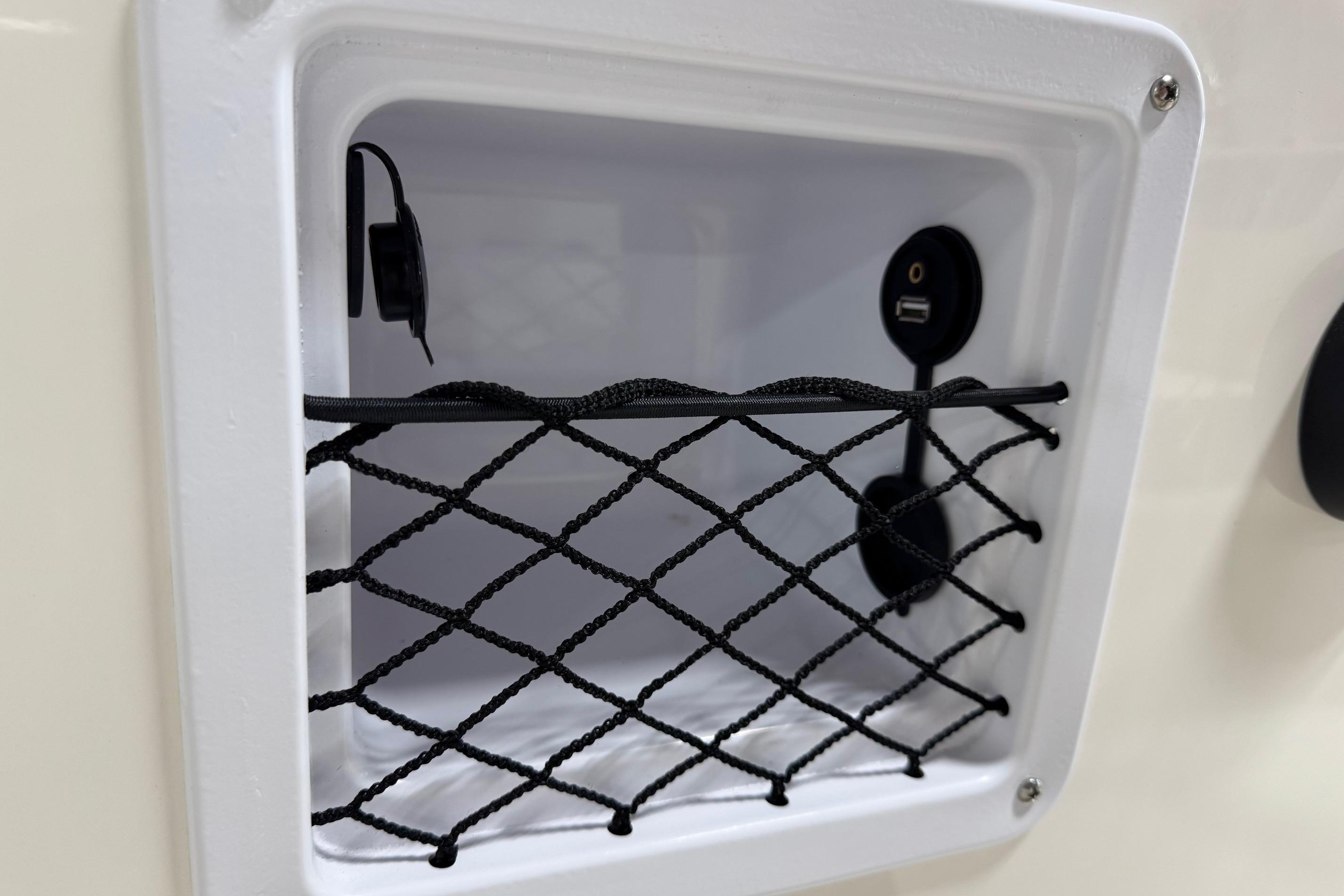Storage compartment with USB port in 2026 Bayliner Element E18 boat.