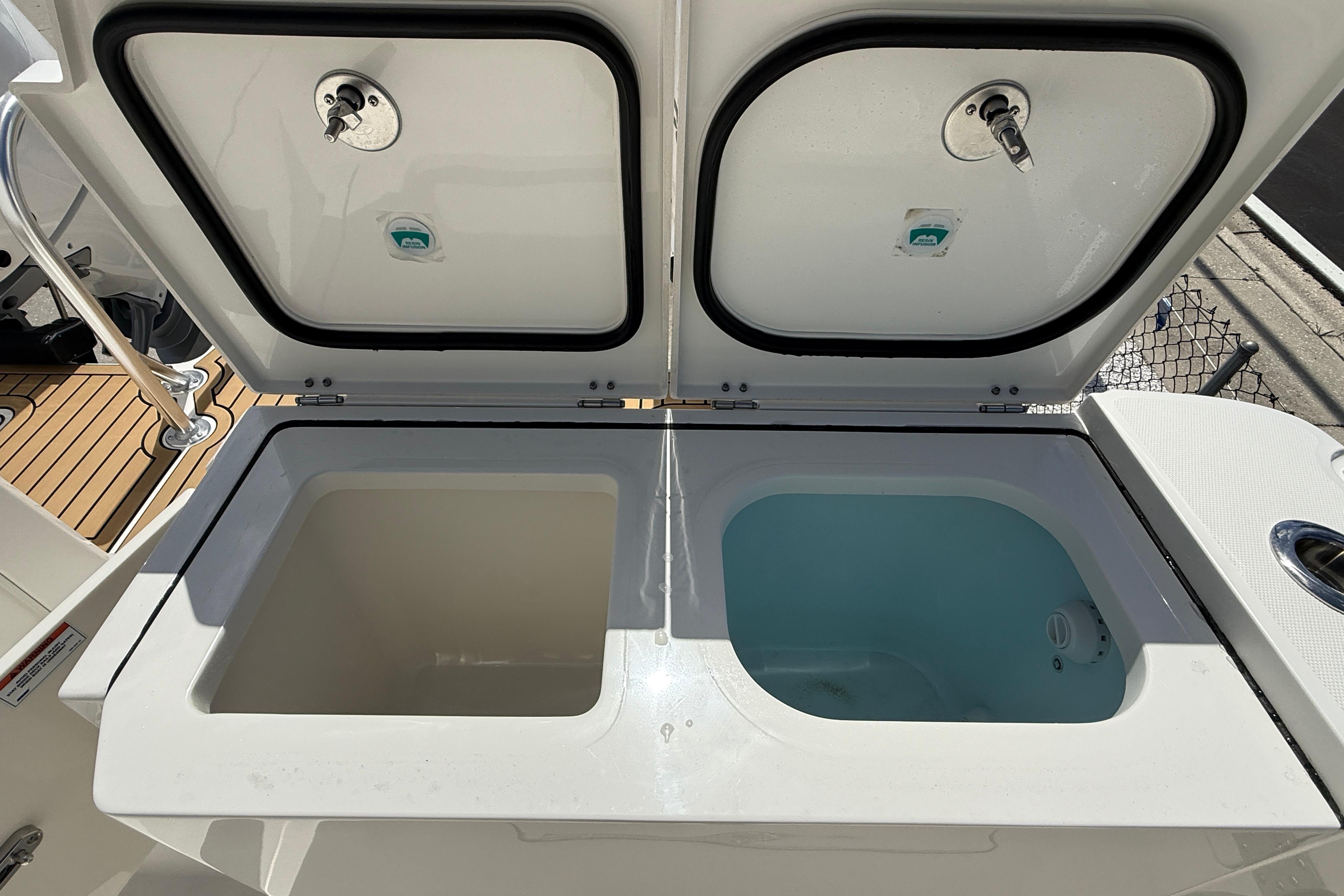 Livewell compartments on 2026 World Cat 400 DC-X Island boat, open lids showing interior.
