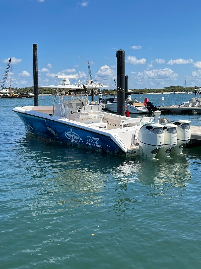 2006 Venture 39 Open boat docked with triple outboard engines.