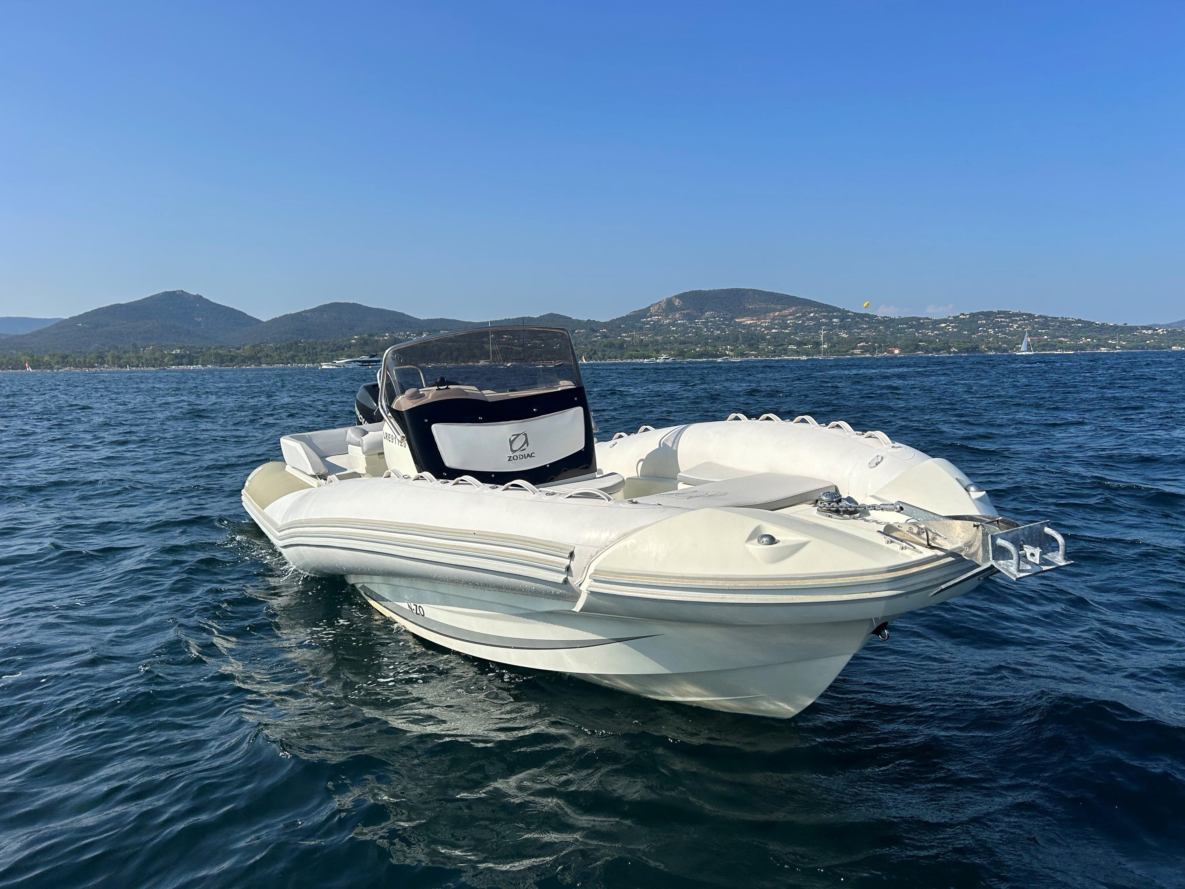 2013 Zodiac N-ZO 760 boat on calm sea with scenic mountain backdrop.