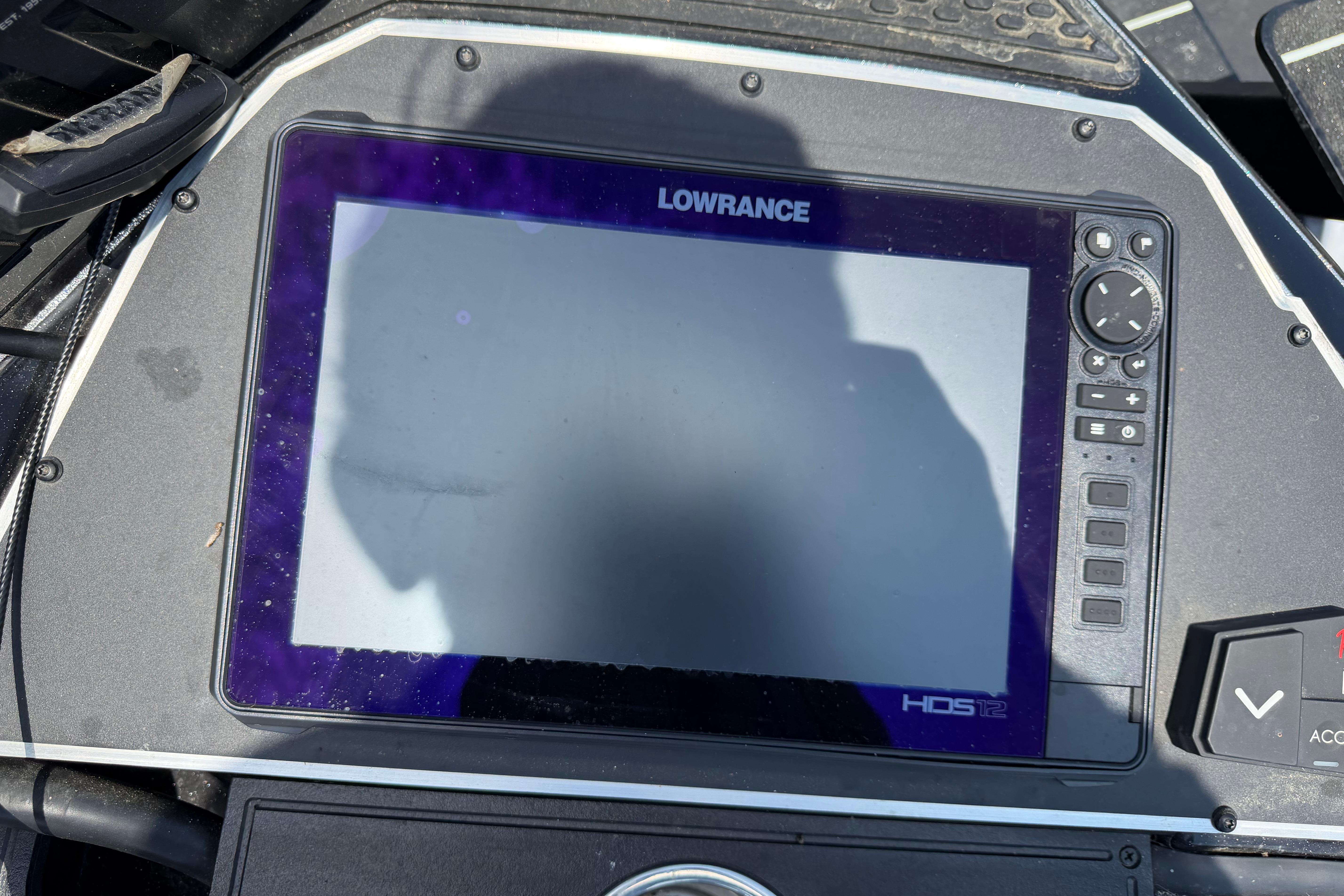 Lowrance HDS-12 fishfinder on 2023 Ranger Z520R boat dashboard, shadow visible on screen.