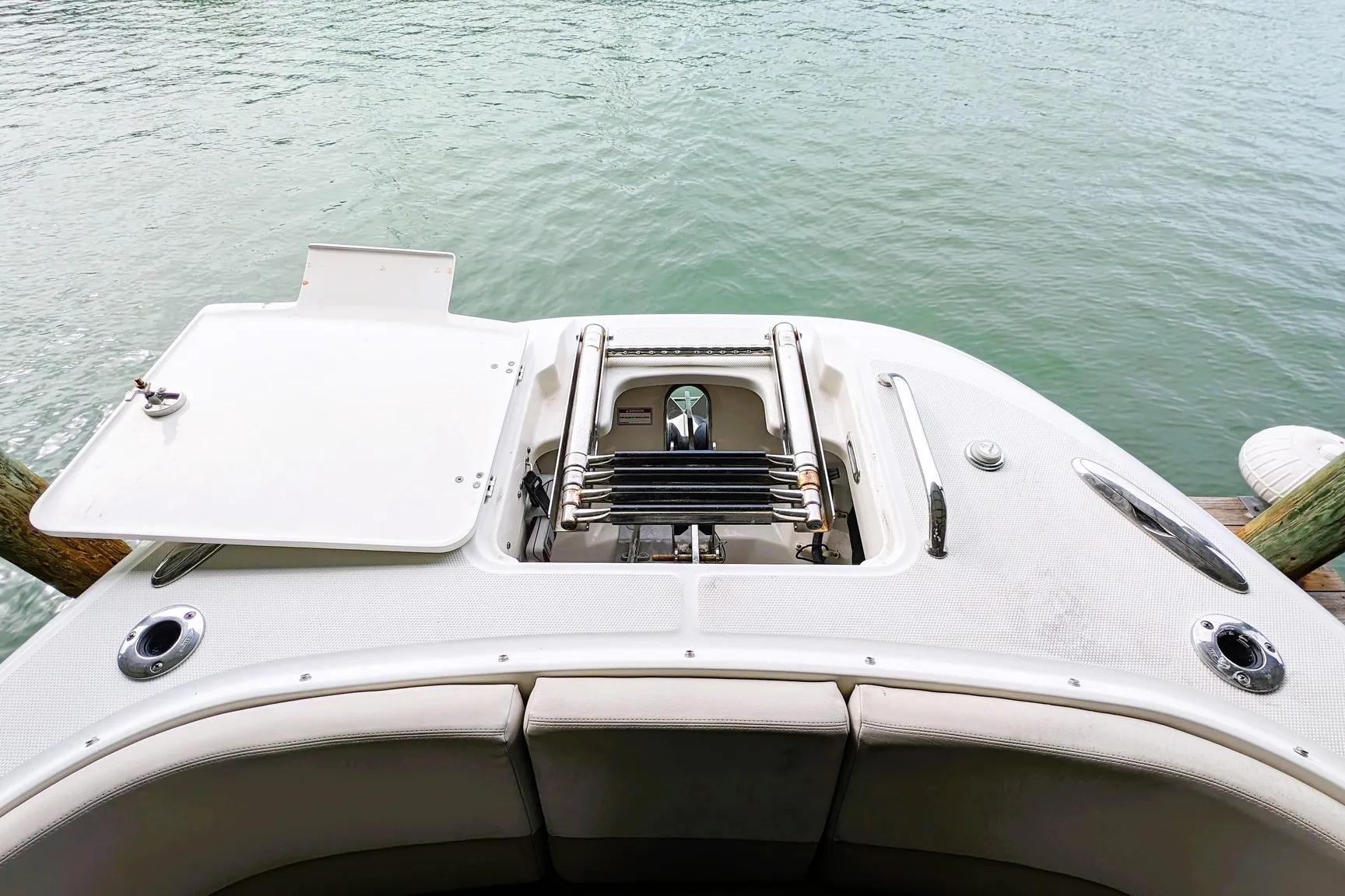 2017 Boston Whaler 320 Vantage boat stern with open hatch and ladder, near water.
