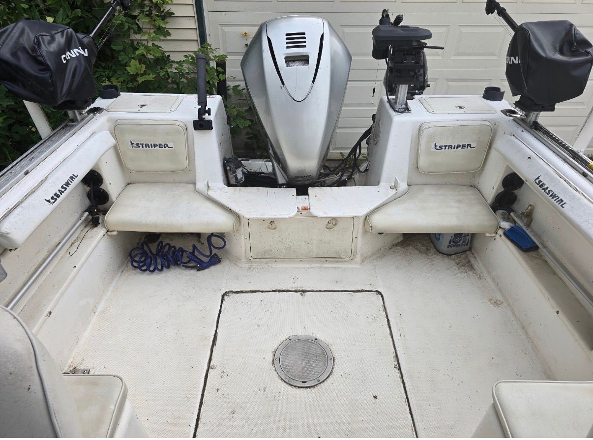 The image shows the cockpit of a 1999 Seaswirl Striper 2100 with two benches and an outboard motor.