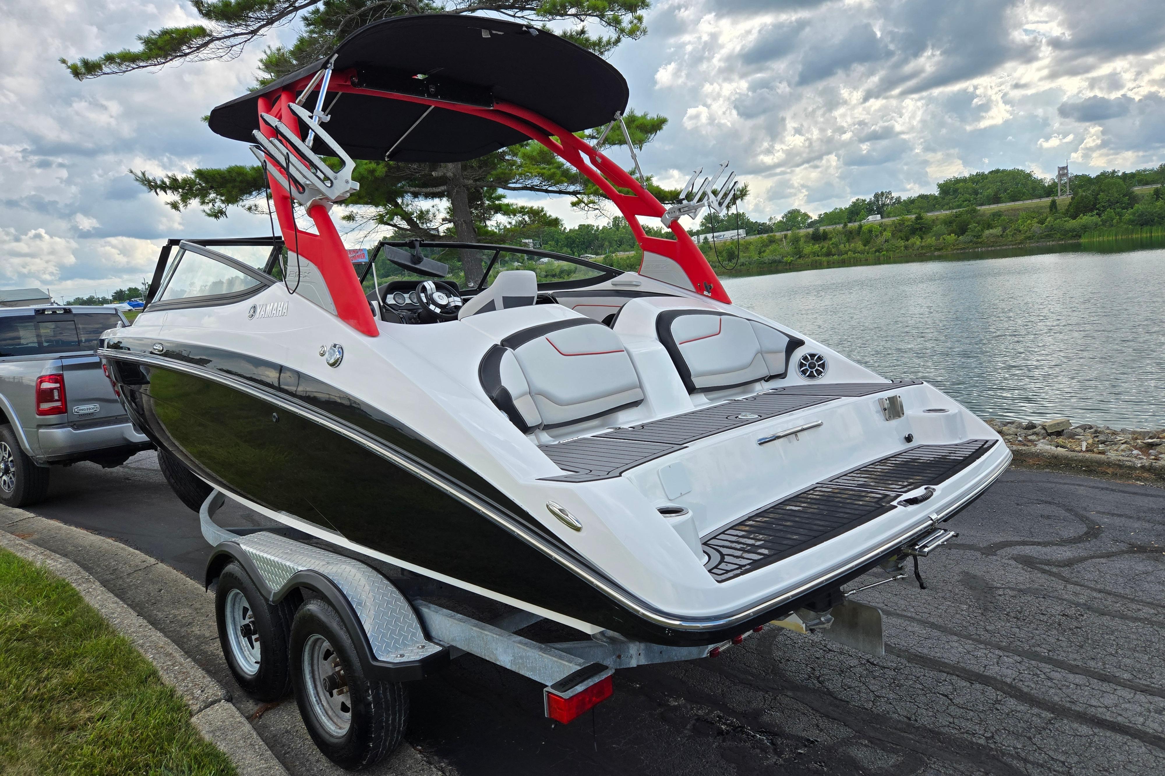 2018 Yamaha Boats 212X on trailer by a scenic lake.