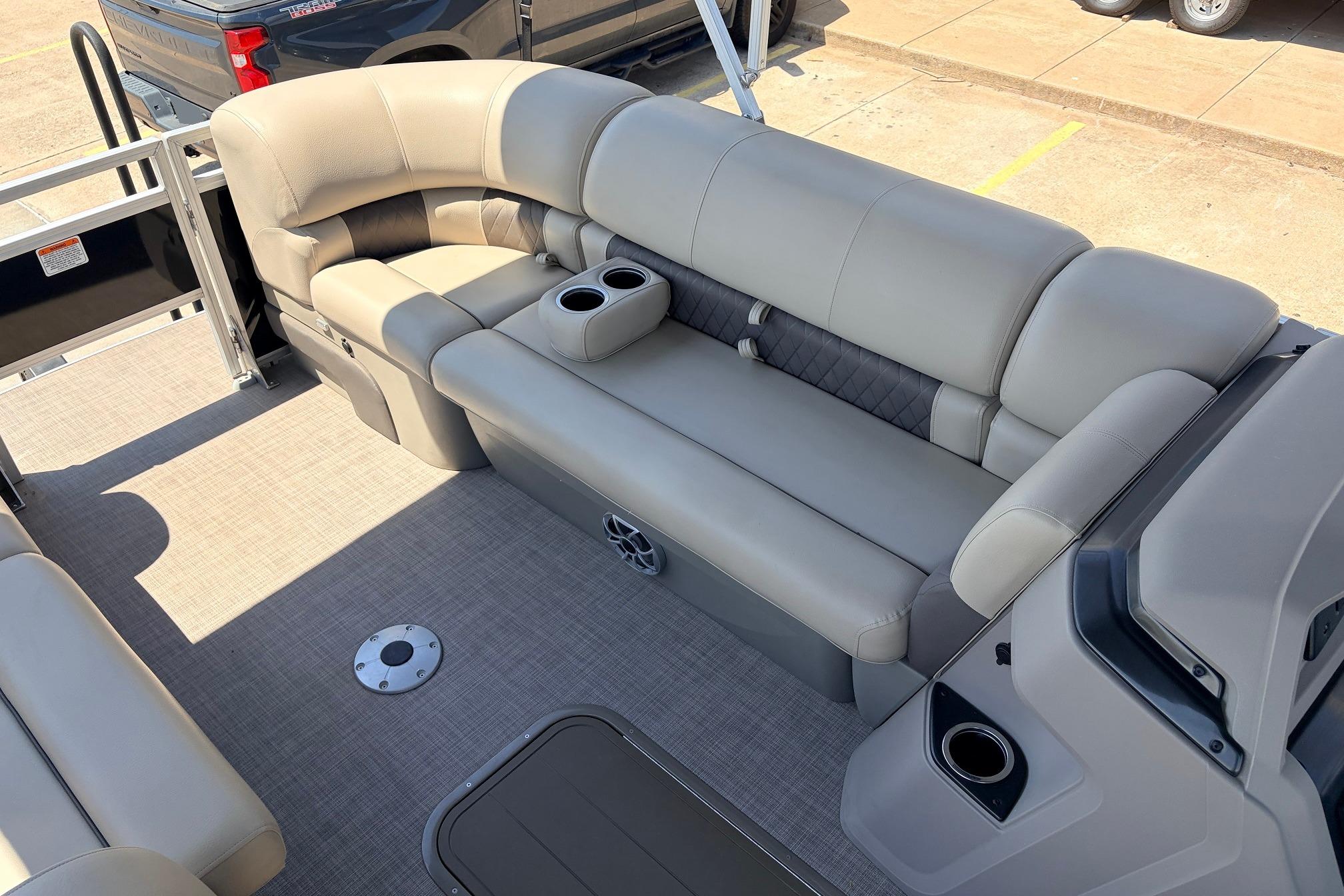 2024 Sun Tracker SportFish 22 XP3 pontoon boat interior with beige seating and cup holders.