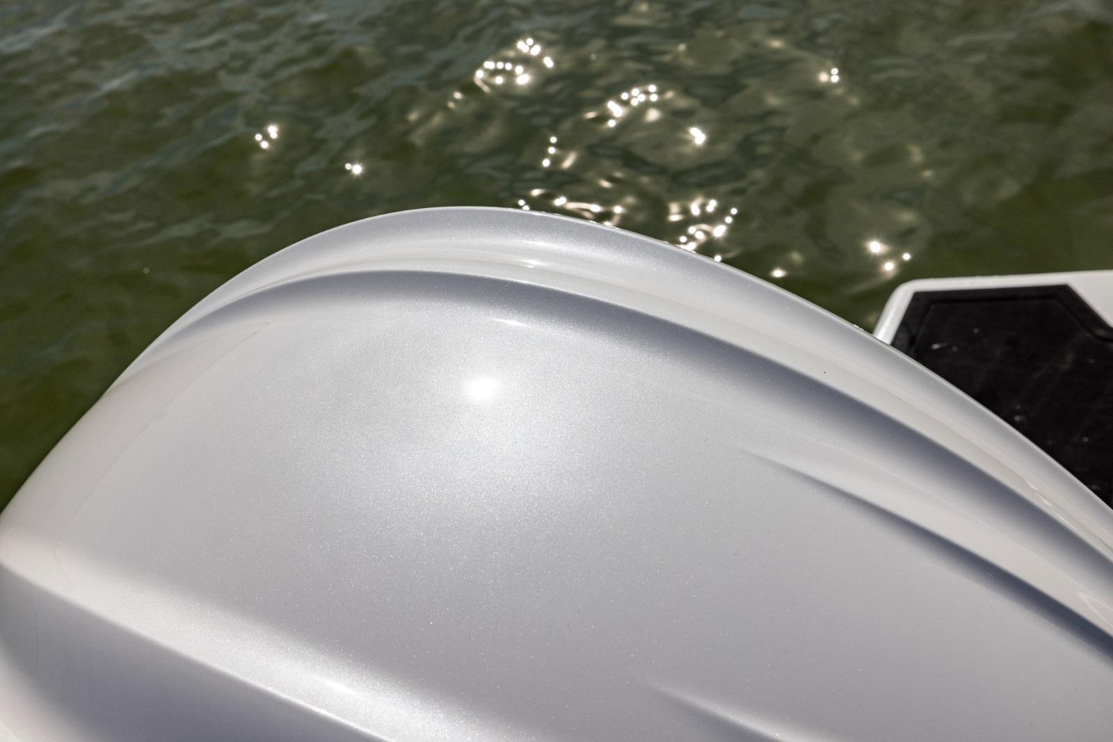 Sleek white surface of Iron 707 boat, 2022 model, reflecting sunlight on water.