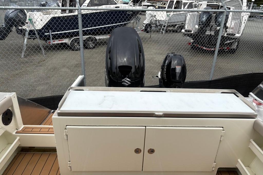 Boat deck with Ortun EC276 outboard motors, 2025 model, in a marina setting.