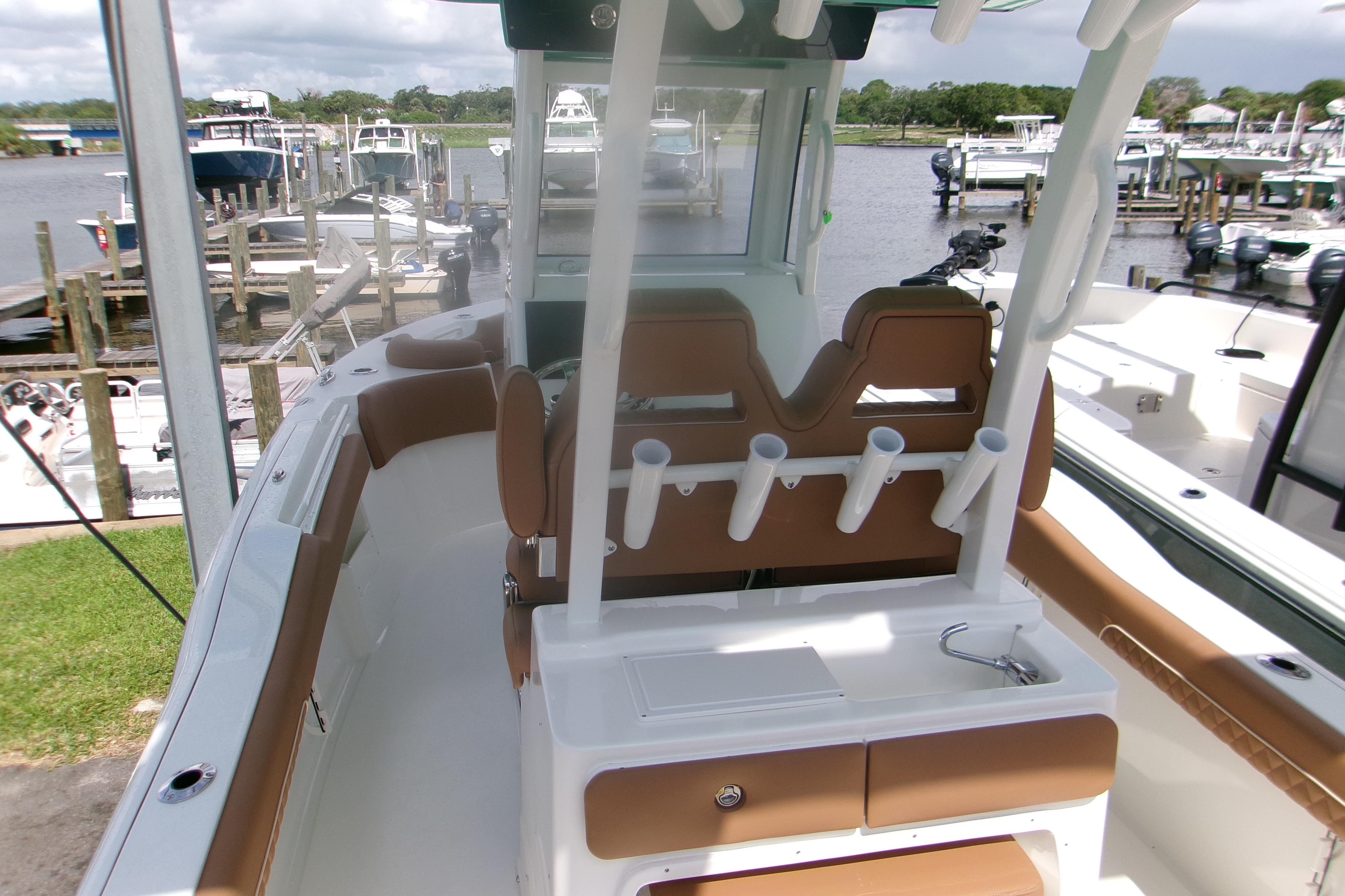 2027 Key West 249 FS boat interior with rod holders and seating at a marina.