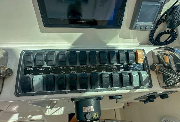 Control panel of a 2006 Tiara Yachts 3200 Open, featuring various switches and navigation equipment.