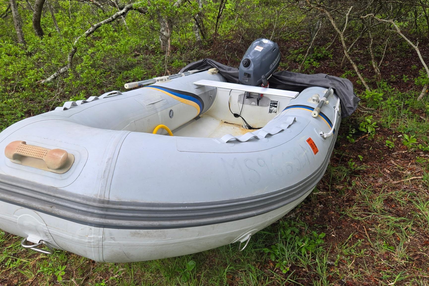 Inflatable boat with outboard motor in a wooded area, Marine Trader 36, 1987 model.