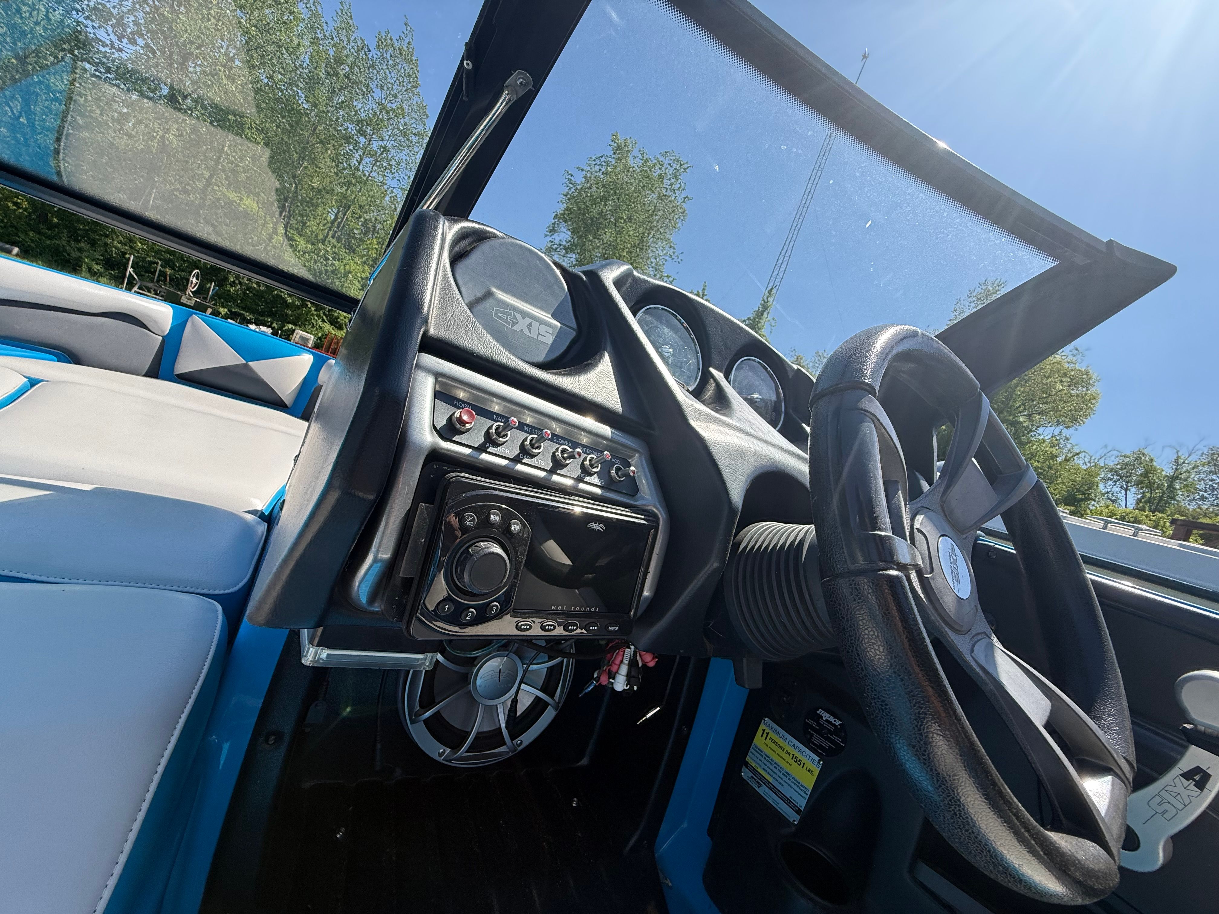Interior view of a 2015 Malibu Axis A20 boat with steering wheel and dashboard.