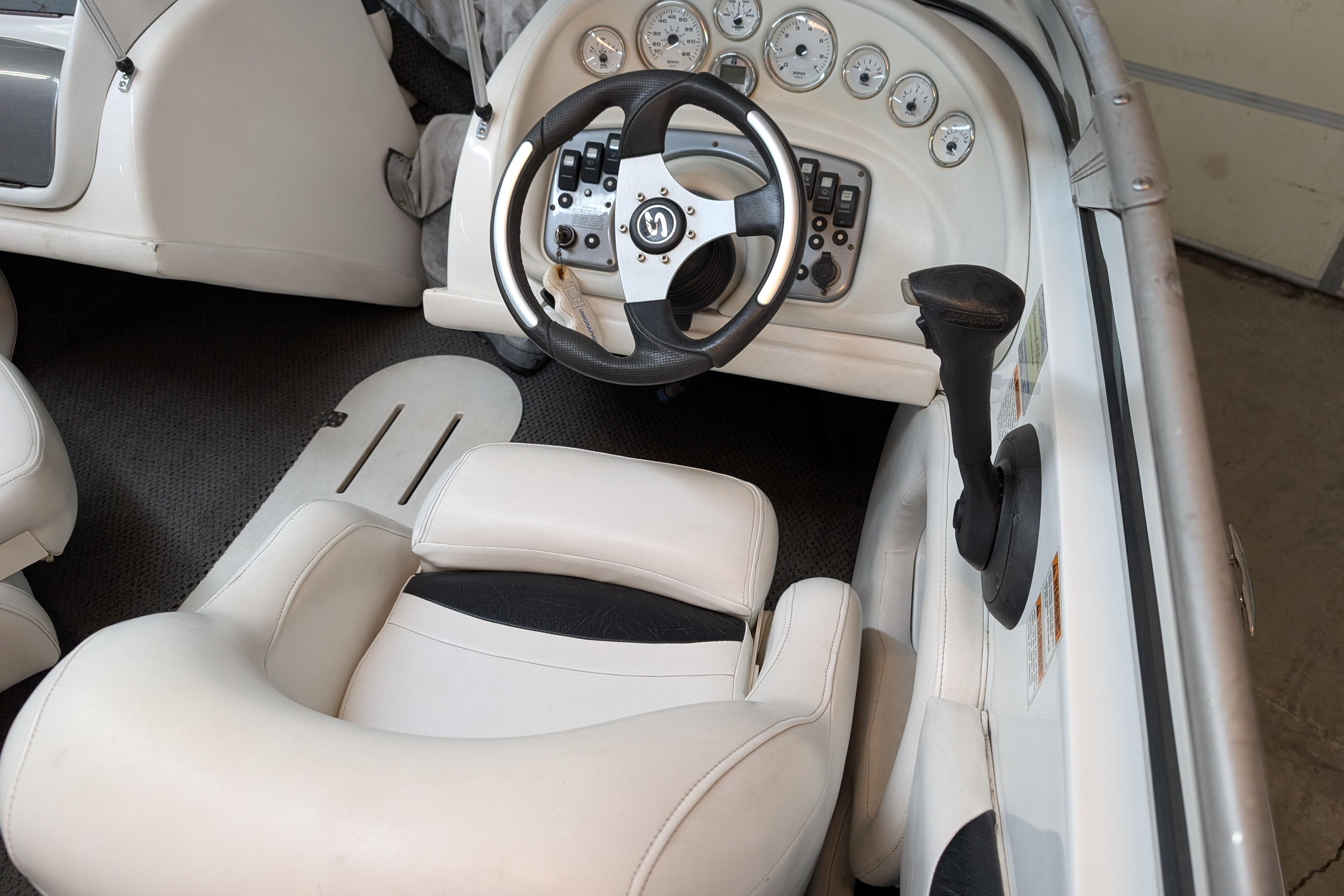 Interior of a 2005 Sylvan V190 I/O boat featuring steering wheel and dashboard controls.