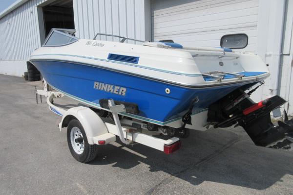 1993 Rinker 186 Captiva boat on trailer, blue and white, parked outside a warehouse.