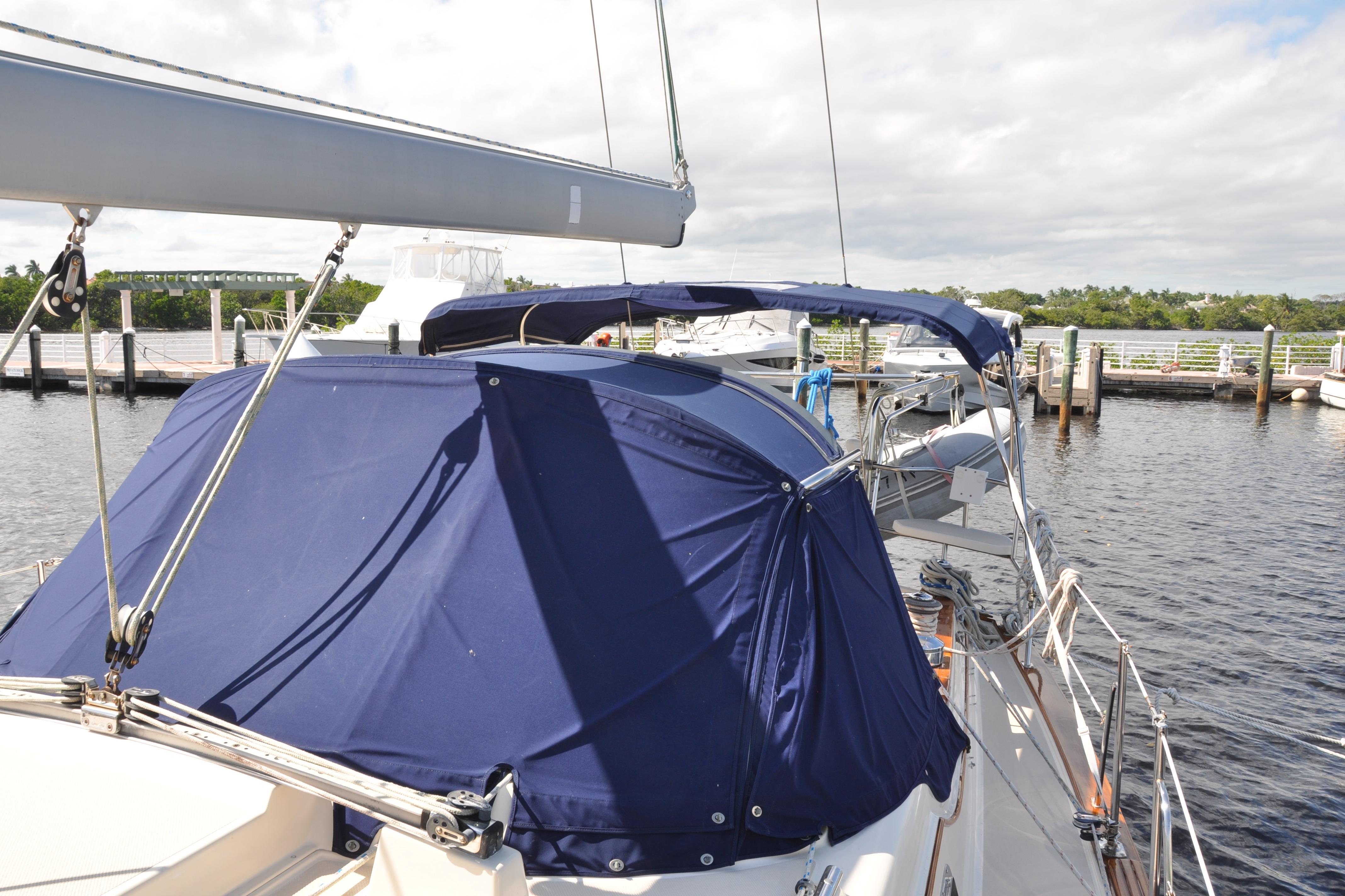 2002 Island Packet 420 sailboat docked with blue canvas covers.