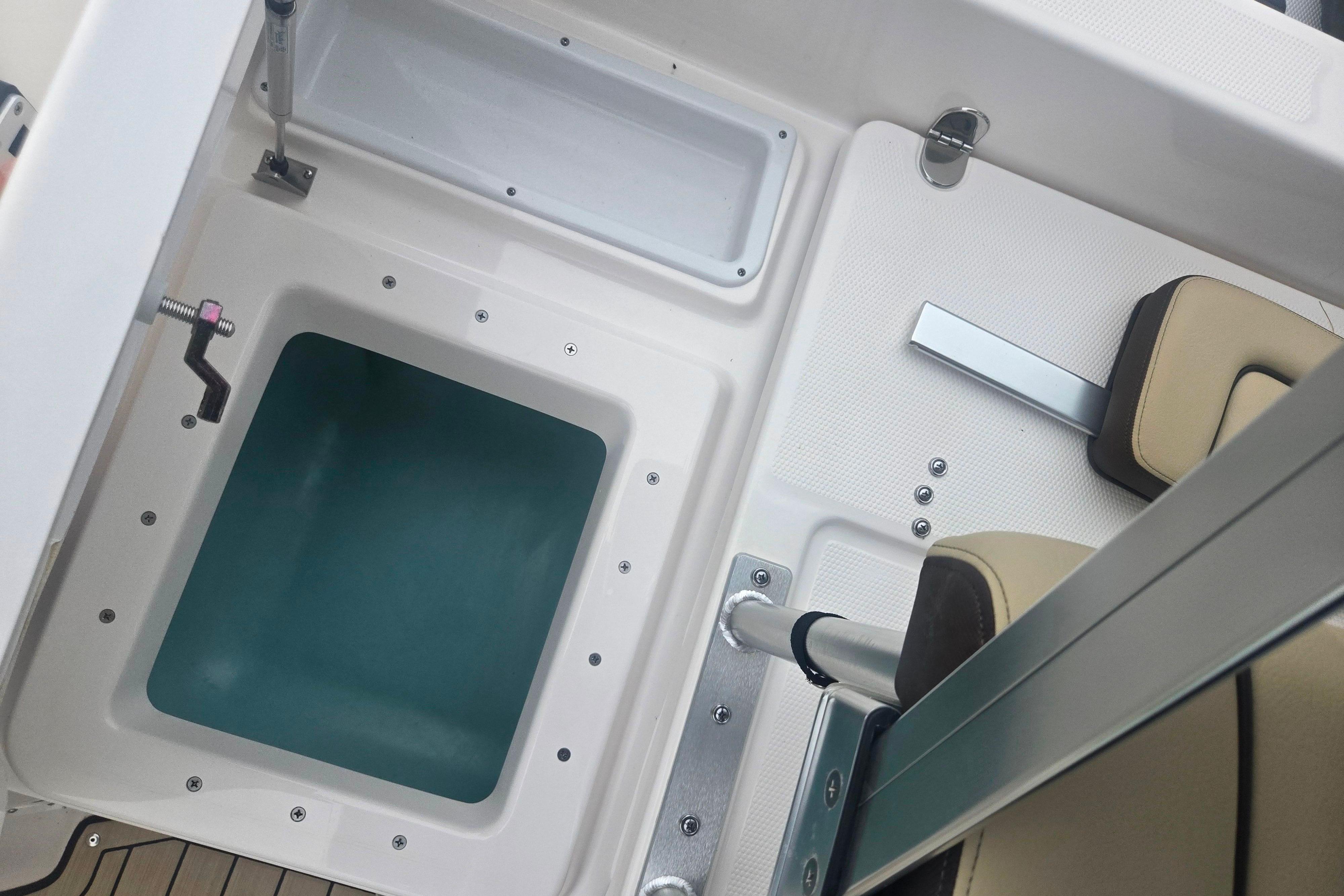Interior view of 2022 Yamaha Boats 195 FSH Sport, featuring seating and storage area.