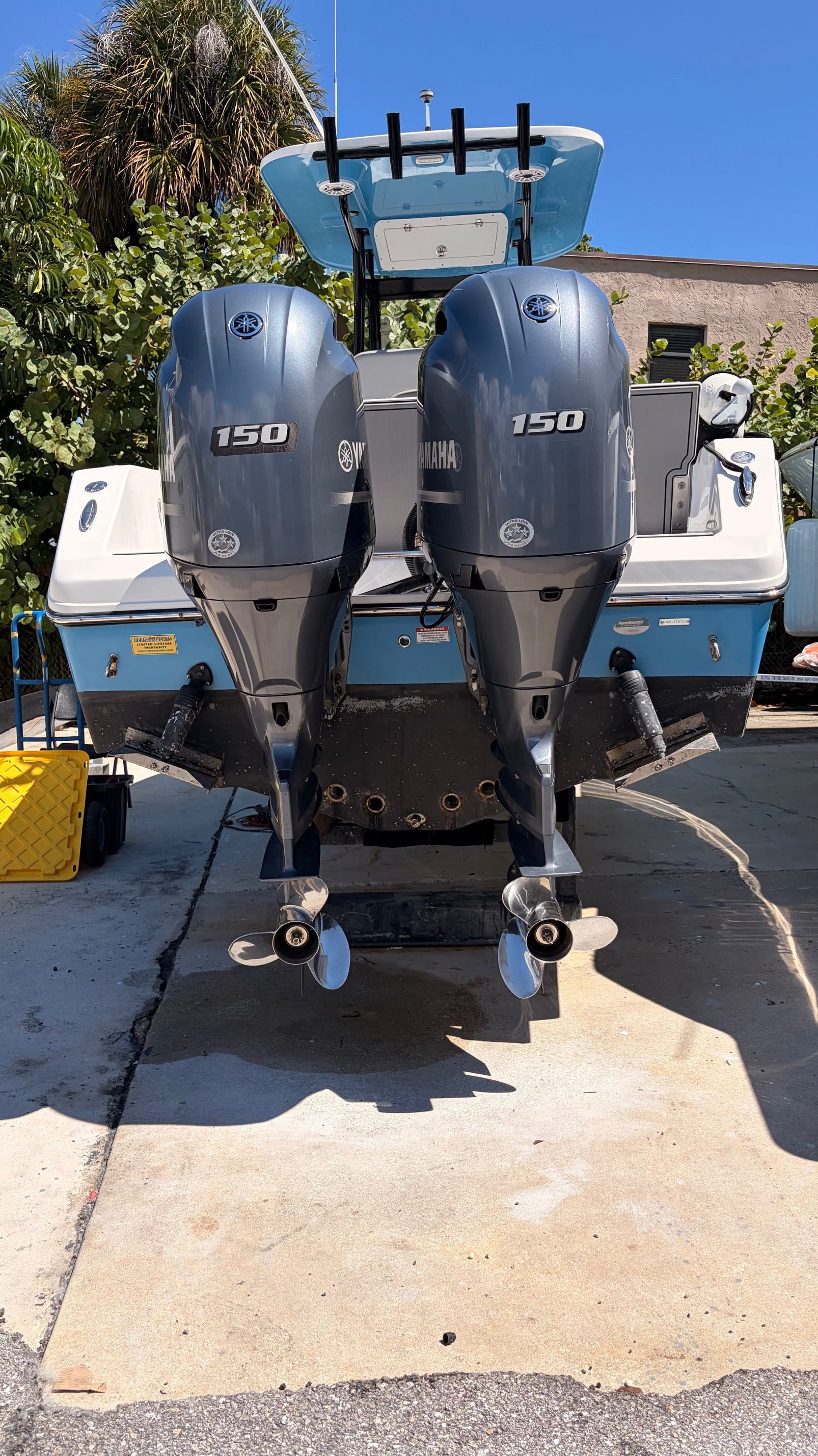 Twin-engine Release 240 RX boat, 2022, parked on pavement.