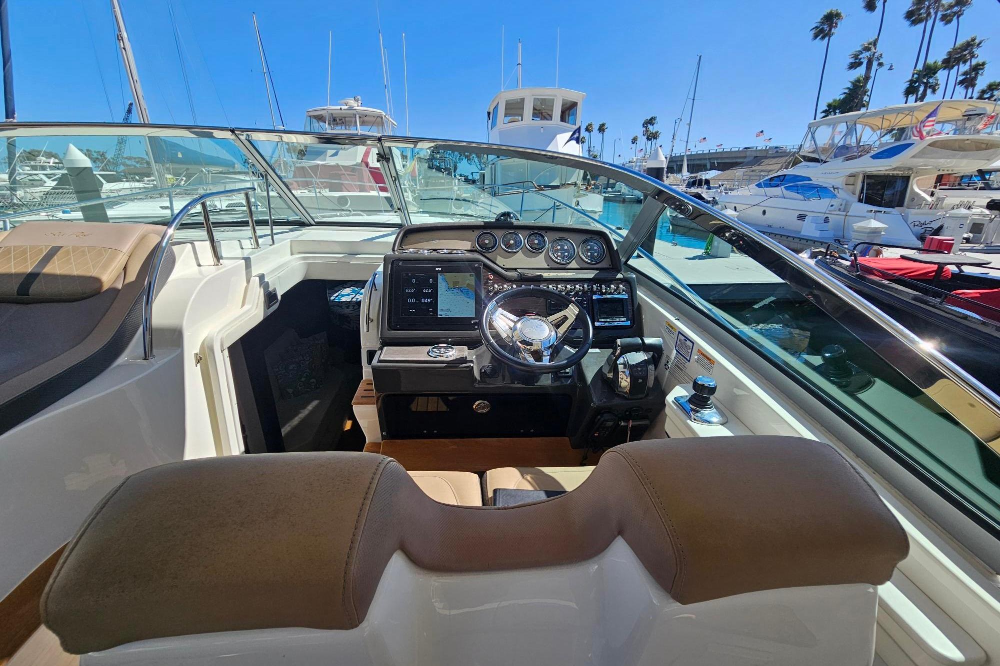 2016 Sea Ray Sundancer 350 cockpit with modern controls, docked at marina.