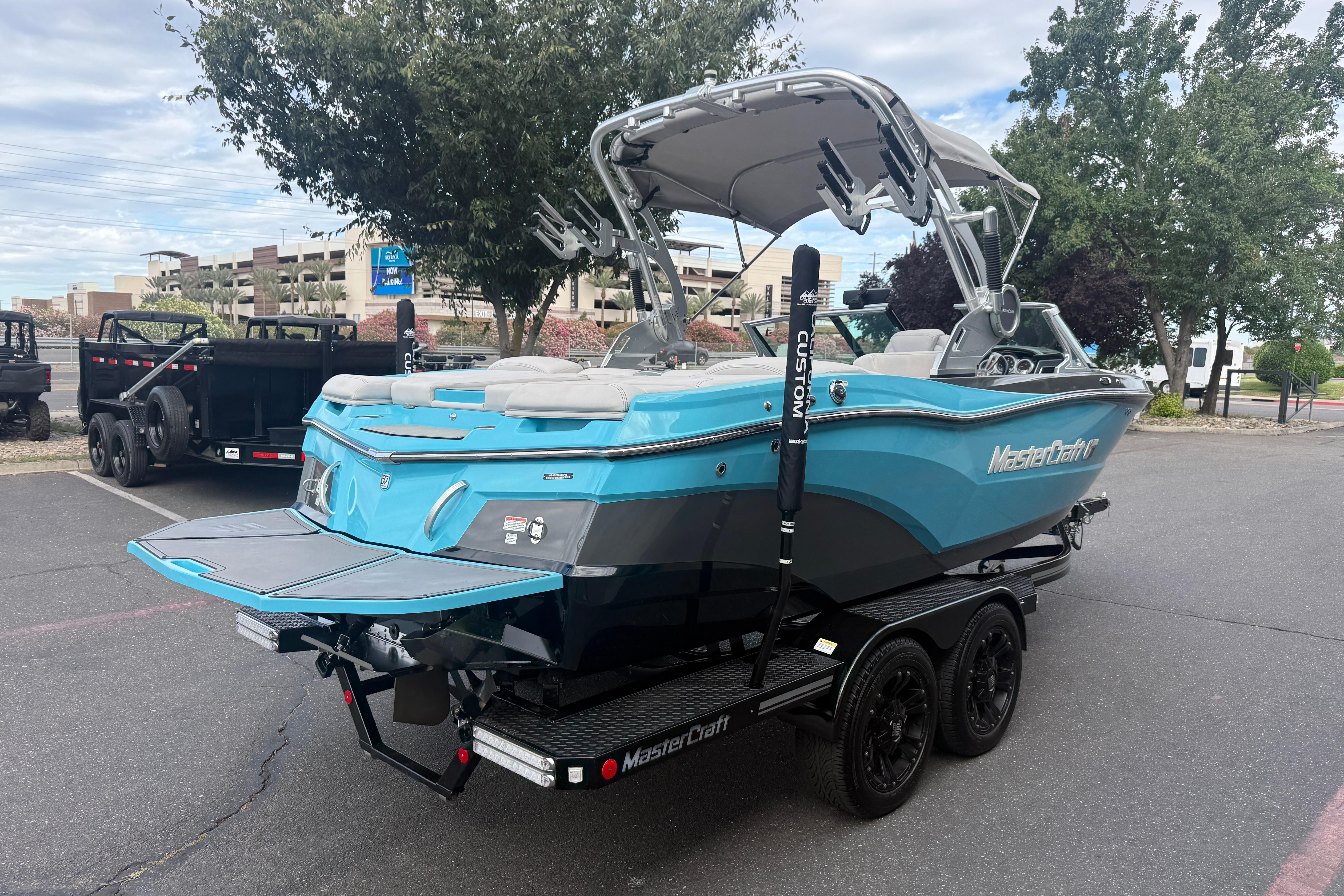 2018 MasterCraft XT21 boat on trailer, parked outdoors, showcasing sleek design and vibrant color.
