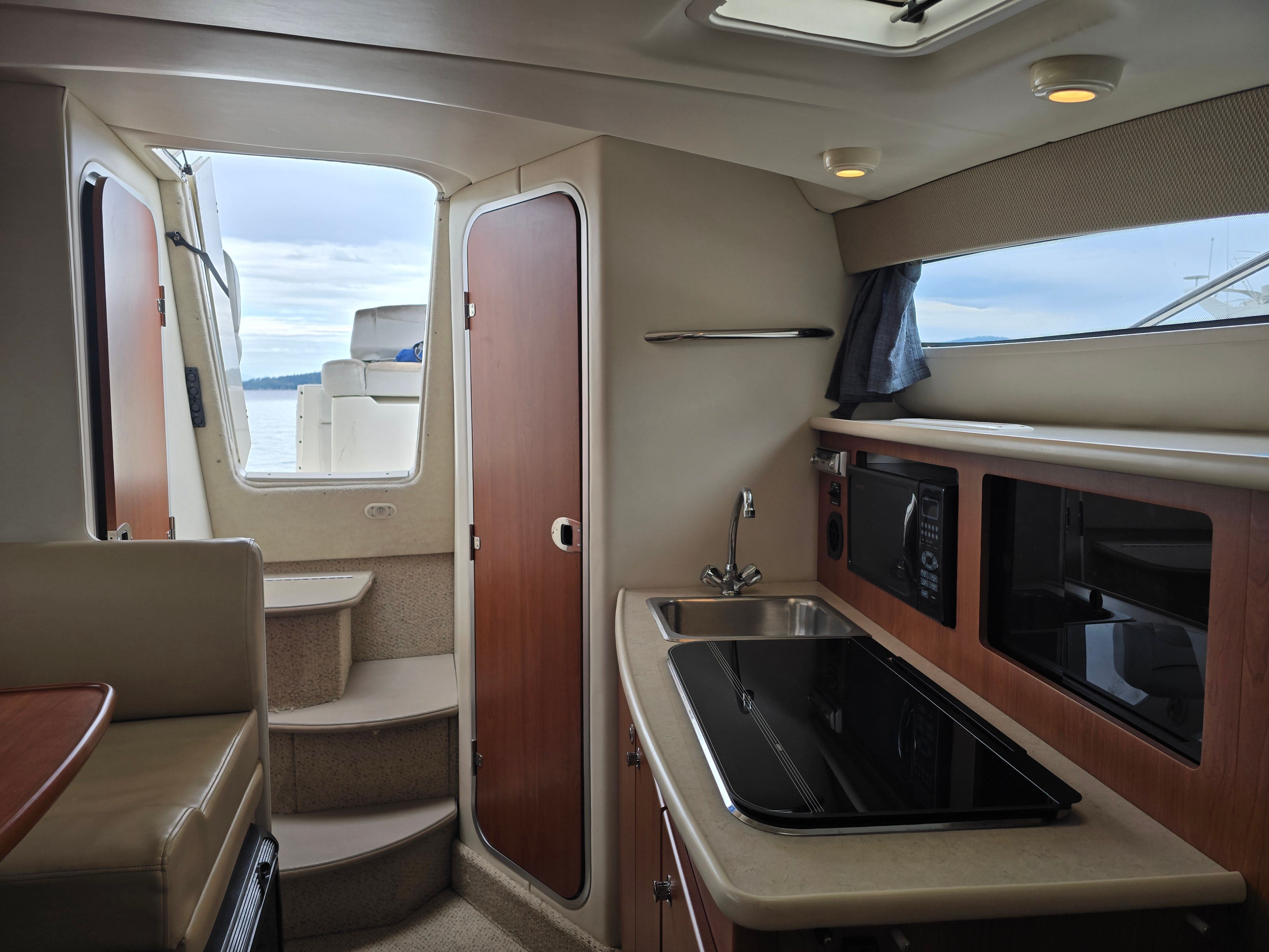 Interior of a Bayliner 285 with a kitchenette and seating area.