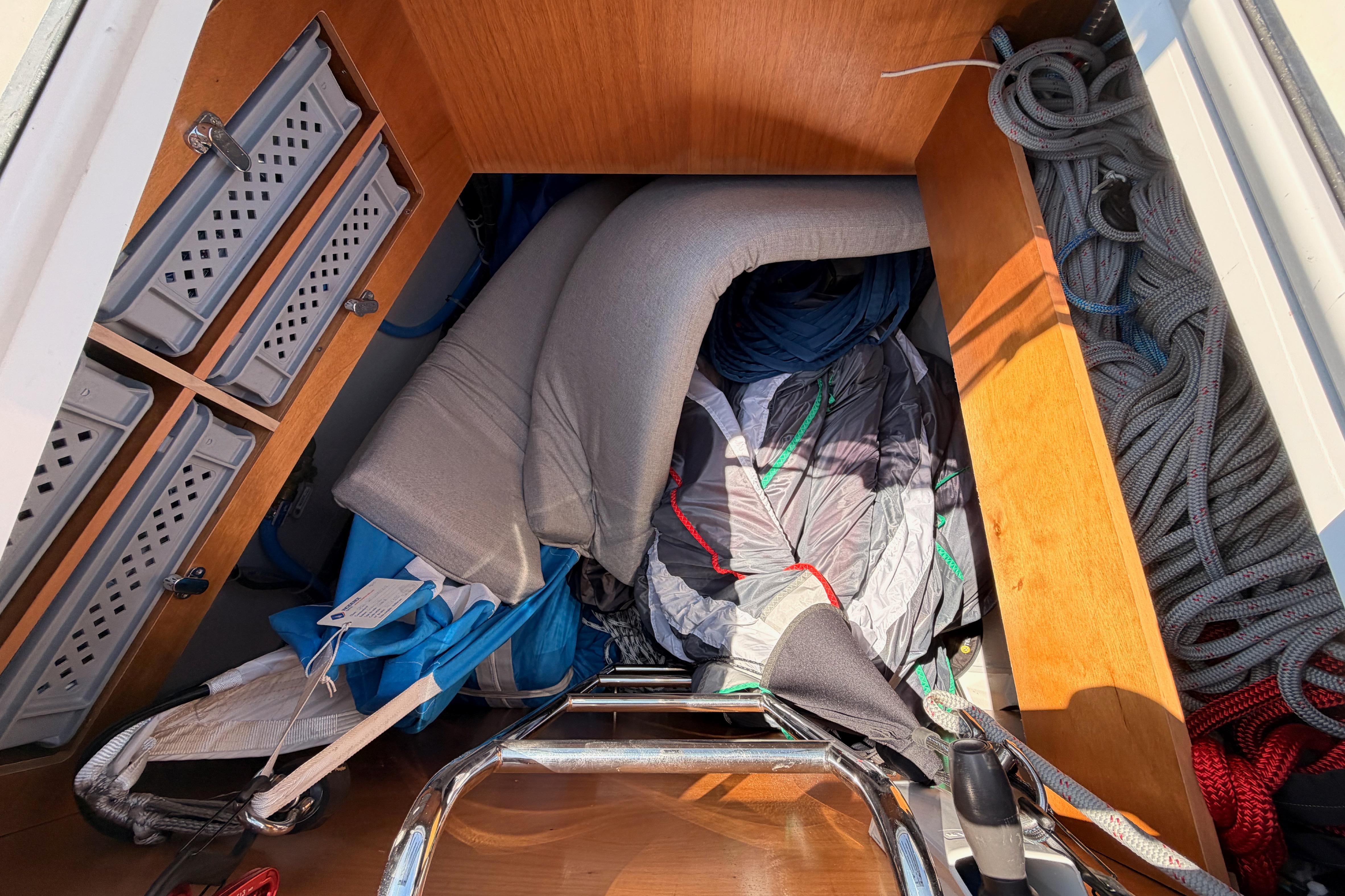 Storage compartment on a 2022 Beneteau Oceanis Yacht 54, filled with ropes and cushions.