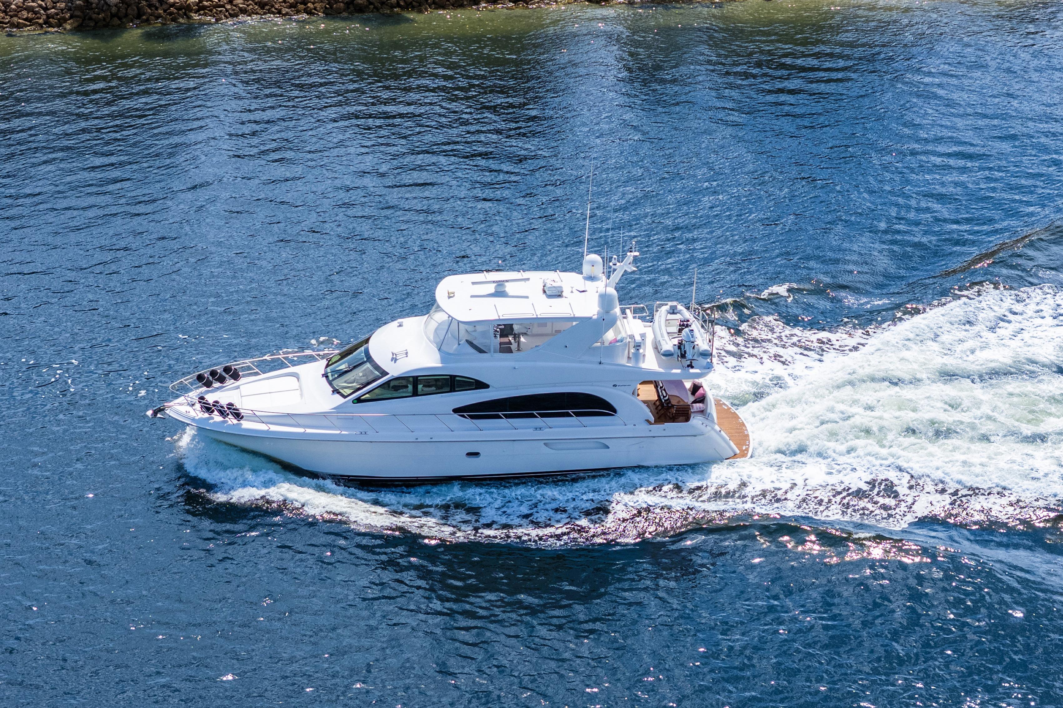 2008 Hatteras 64 Motor Yacht cruising on open water, aerial view.